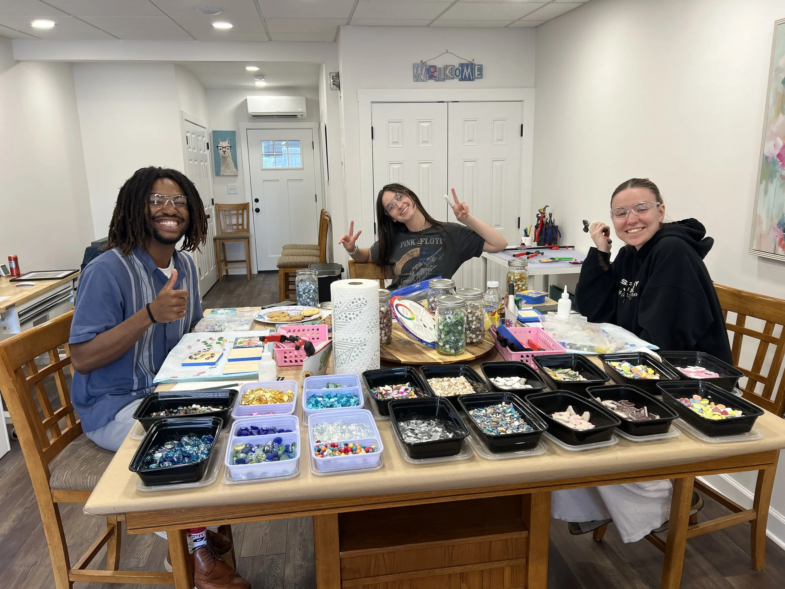 Creative glass art workshop at Lake Geneva Art Studio, where students gather around the table to design colorful projects.