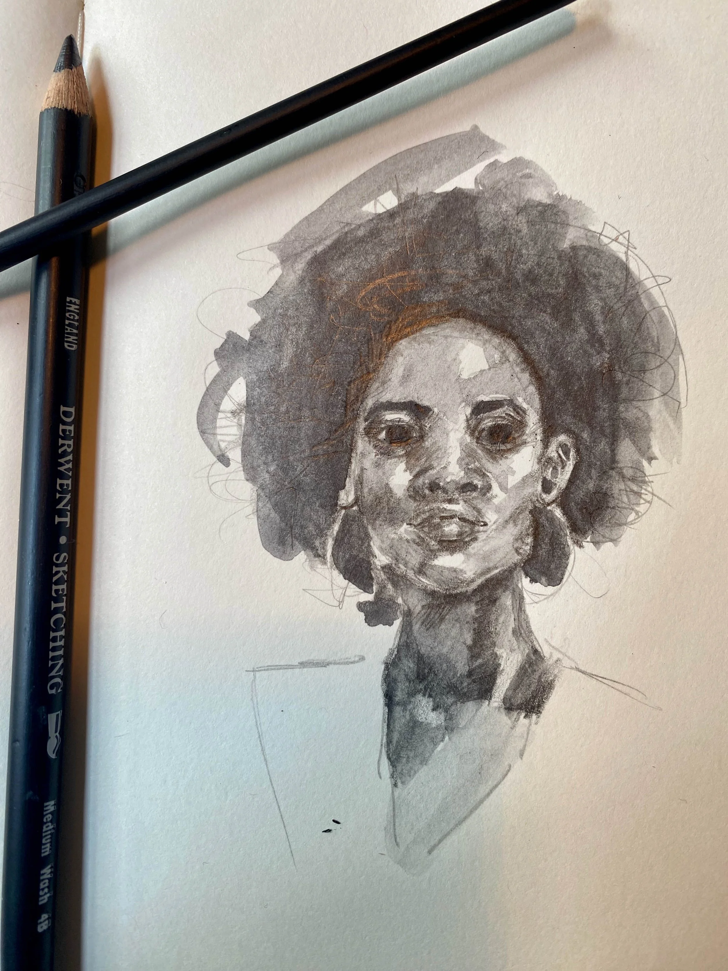 A watercolor portrait of a woman with large, textured hair, dark eyes, and a serious expression on her face. Two black pens are placed on the paper next to the drawing.
