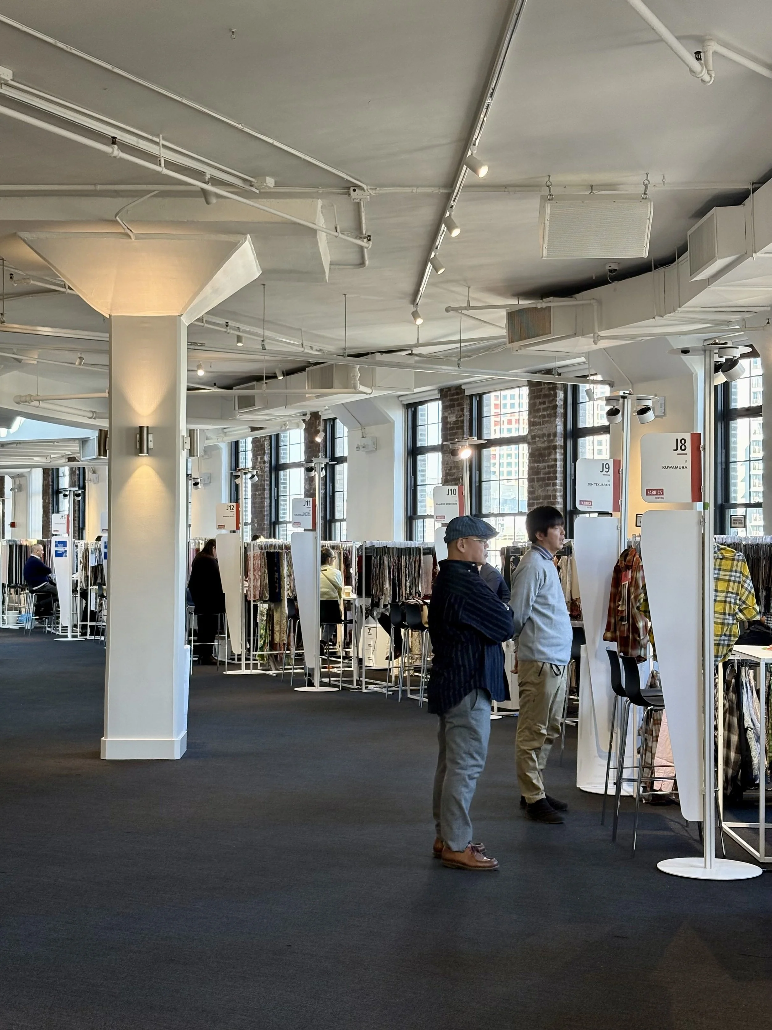 Multiple textile stalls well lit rounded hall