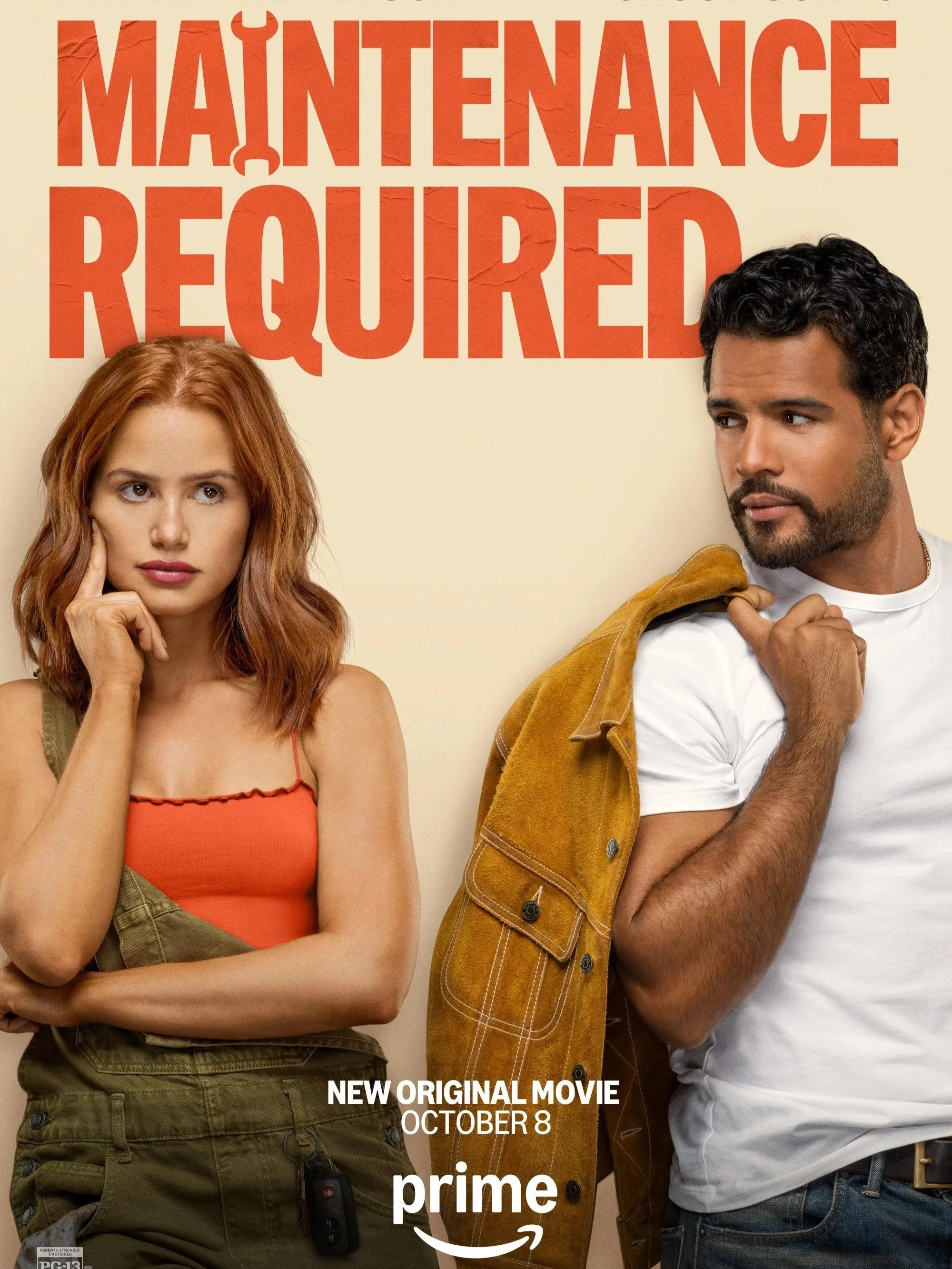 A promotional poster for the movie 'Maintenance Required' showing a woman with red hair and a man with dark hair standing against a cream background. The woman is on the left, touching her face with her right hand, and the man is on the right, holdin