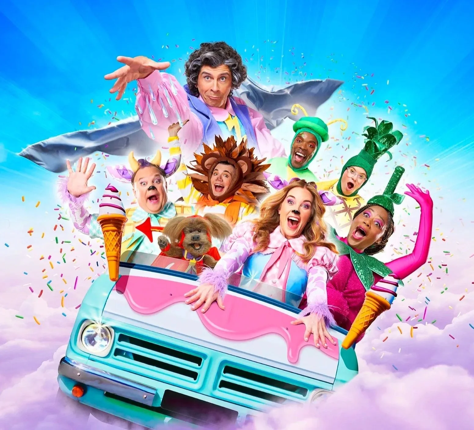 Group of people in colorful costumes riding in a pink van through a cloud of rainbow-colored confetti, with a bright blue sky background.