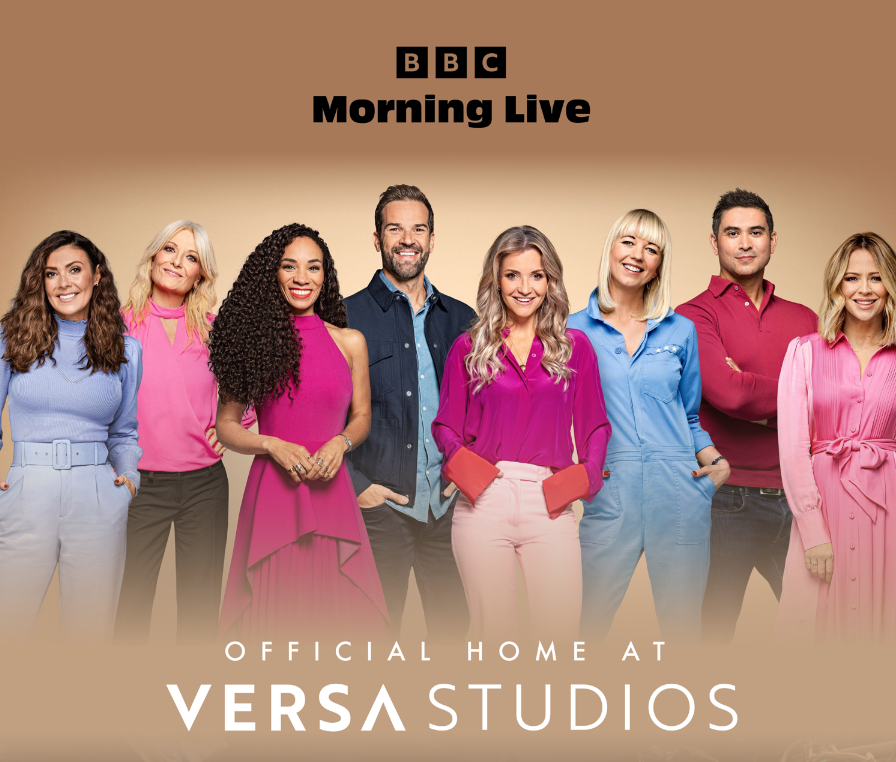 Group of seven diverse people smiling and posing together for a promotional photo for BBC Morning Live and Versa Studios, set against a beige background.