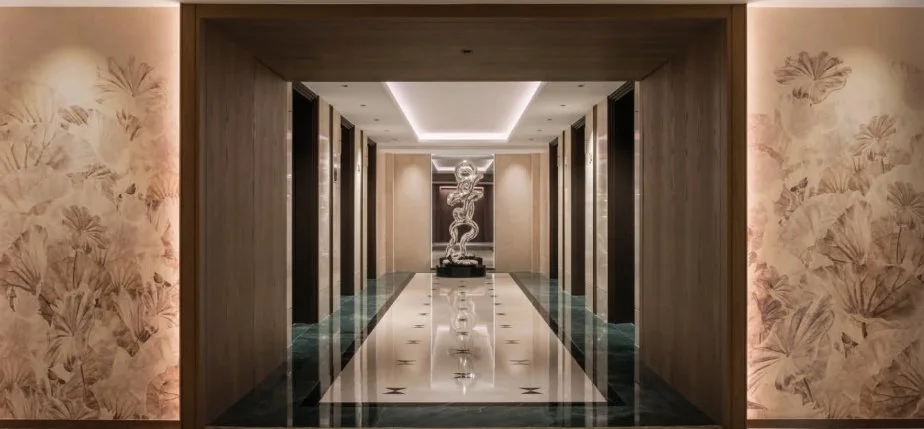 Marriot Hotel Elegant hotel corridor with a marble floor, floral wallpaper, and a sculpture at the end of the hallway.