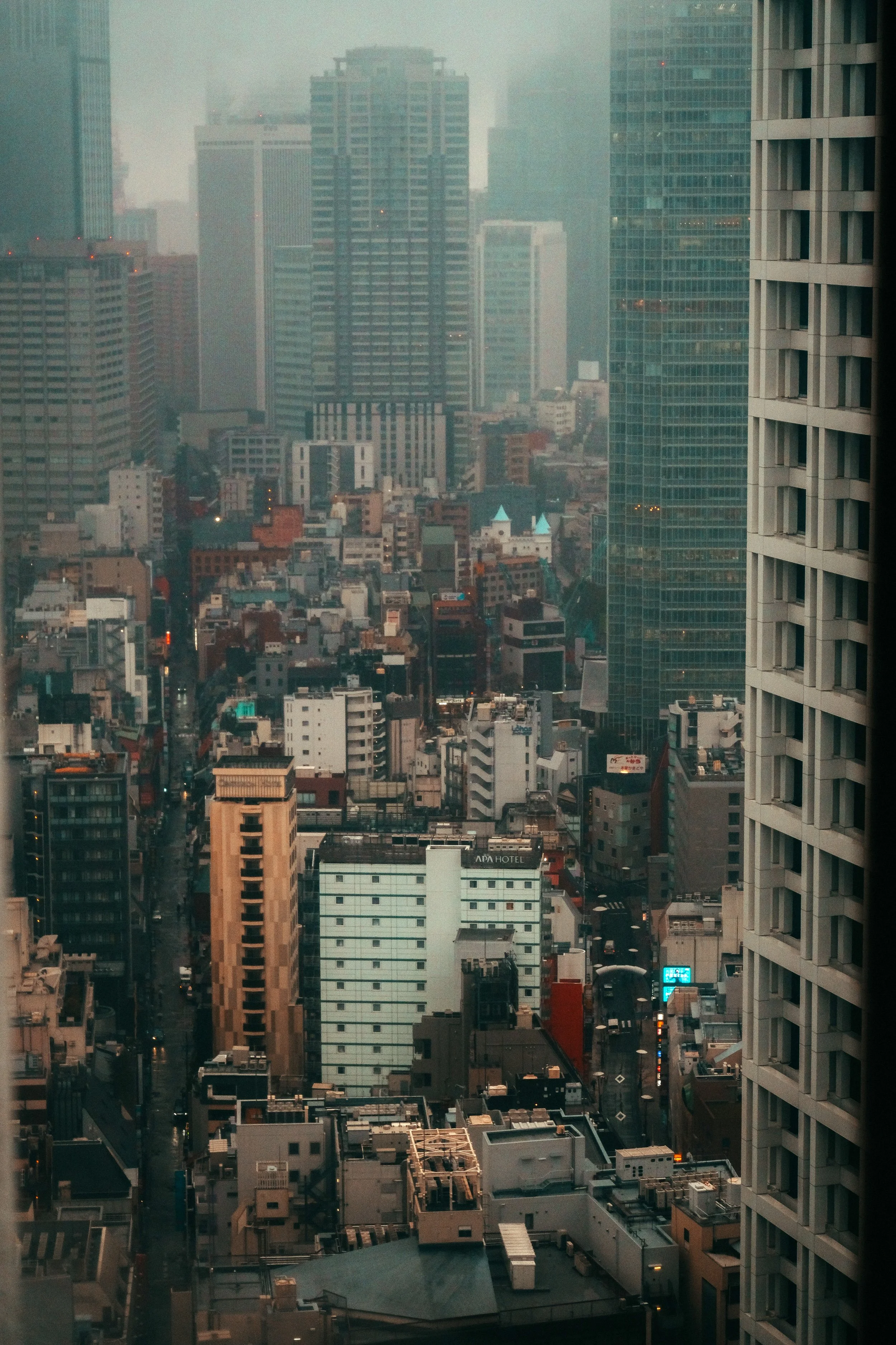 Stadtansicht mit hohen Gebäuden und Wolkenkratzern bei nebligem Wetter.