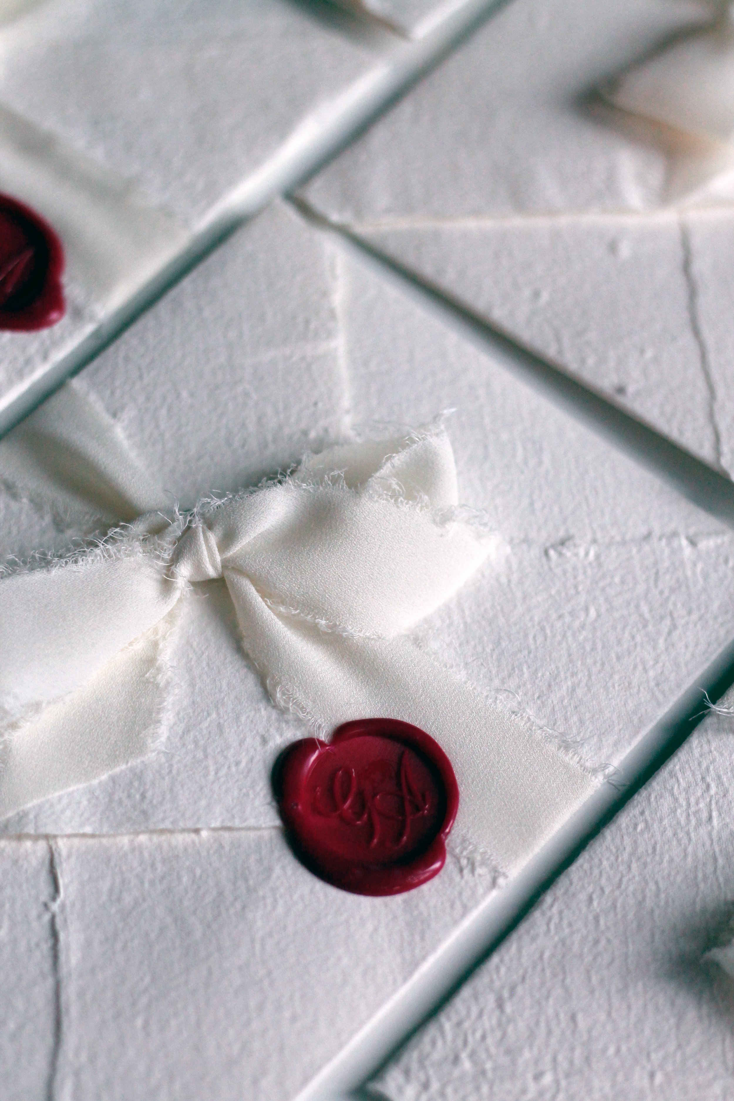 Confezioni regalo bianche con nastri di raso e sigilli di ceralacca rosso