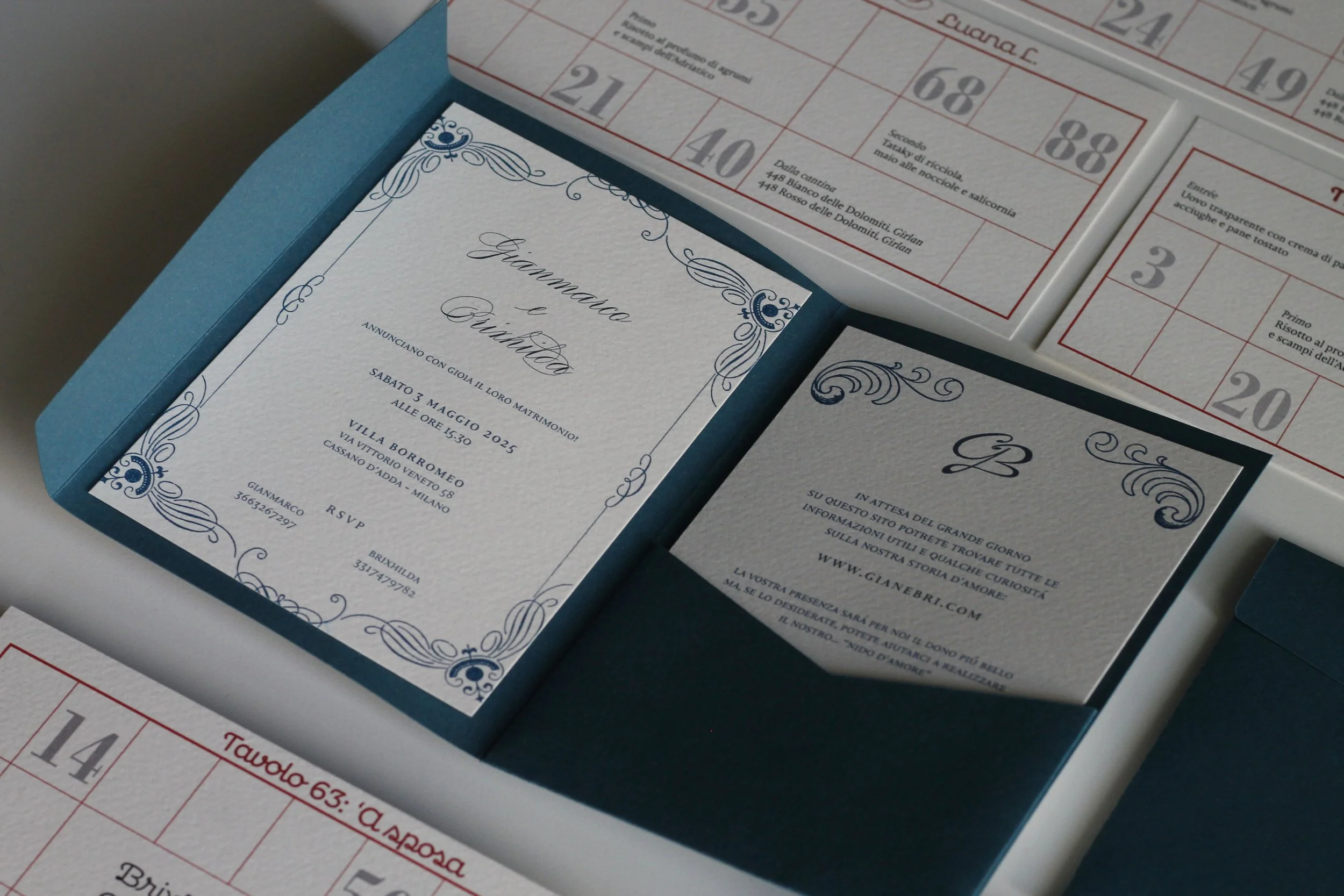 Invito di matrimonio con decorazioni blu, dettagli dell'evento, data, ora e location, in una scatola blu. Al lato, schede di bingo con numeri e istruzioni in italiano.