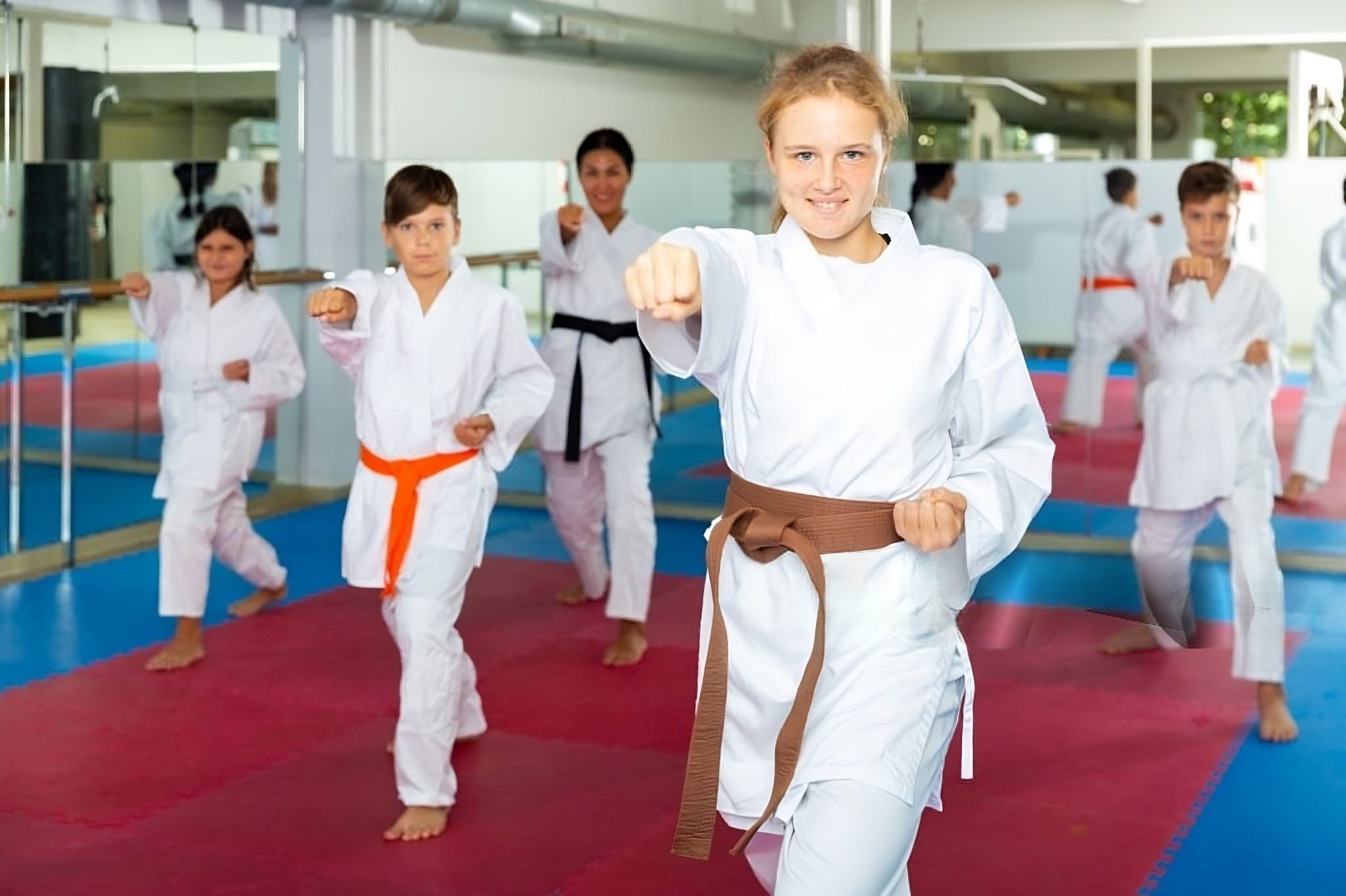 Children practicing martial arts in a dojo, in Floreat, Perth,  Western Australia. They are wearing white gi uniforms with various colored belts, and performing a martial arts stance.