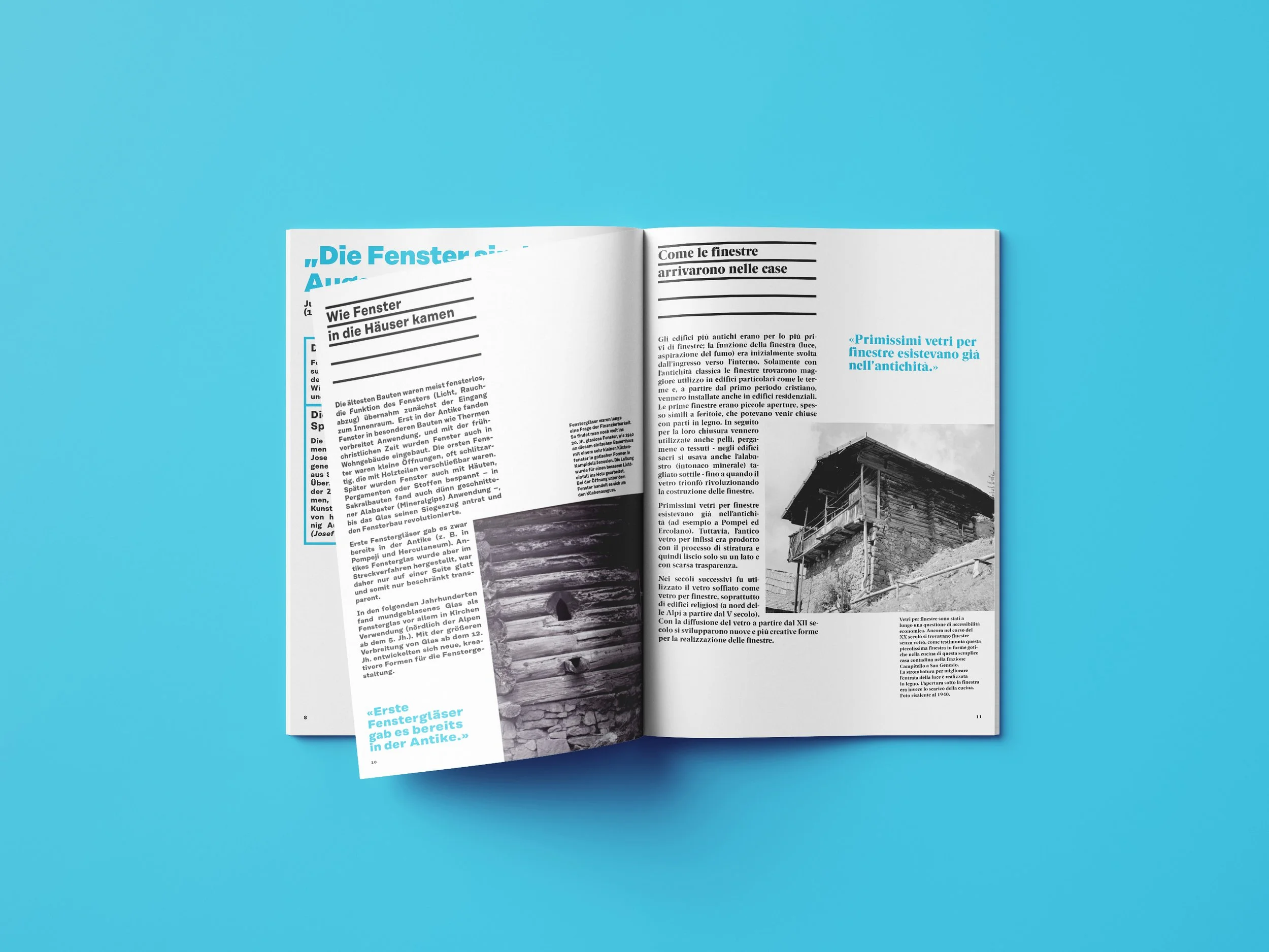 Offen gelegte Zeitschrift mit Text in Deutsch und Italienisch, sowie schwarz-weißen Fotos eines Gebäudes und eines Holzhauses, auf blauem Hintergrund.