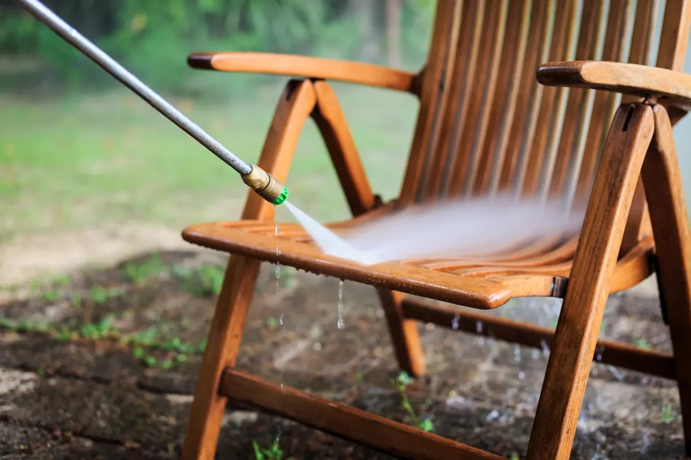 Nettoyage d'une chaise de jardin en bois au jet modulé pour un rafraîchissement complet du mobilier.