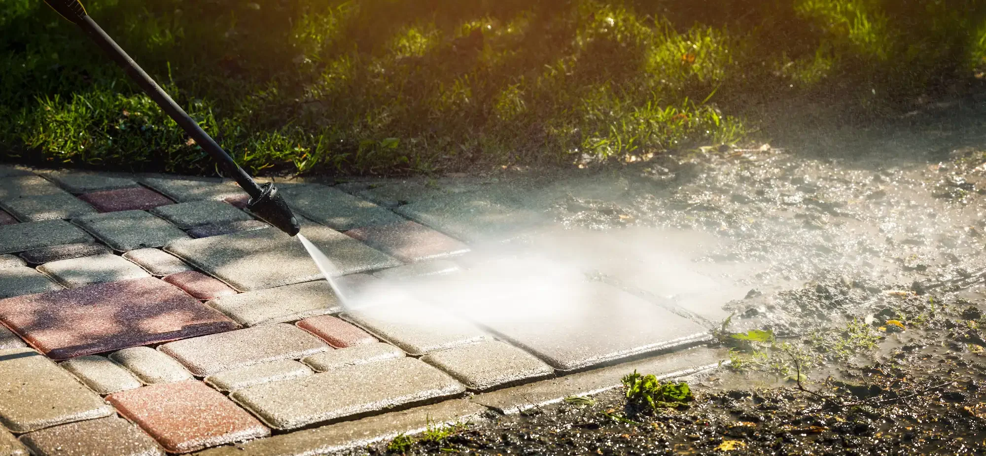 Nettoyage à la lance haute pression maîtrisée des pavés autobloquants de l’allée d’un jardin à Fourques.