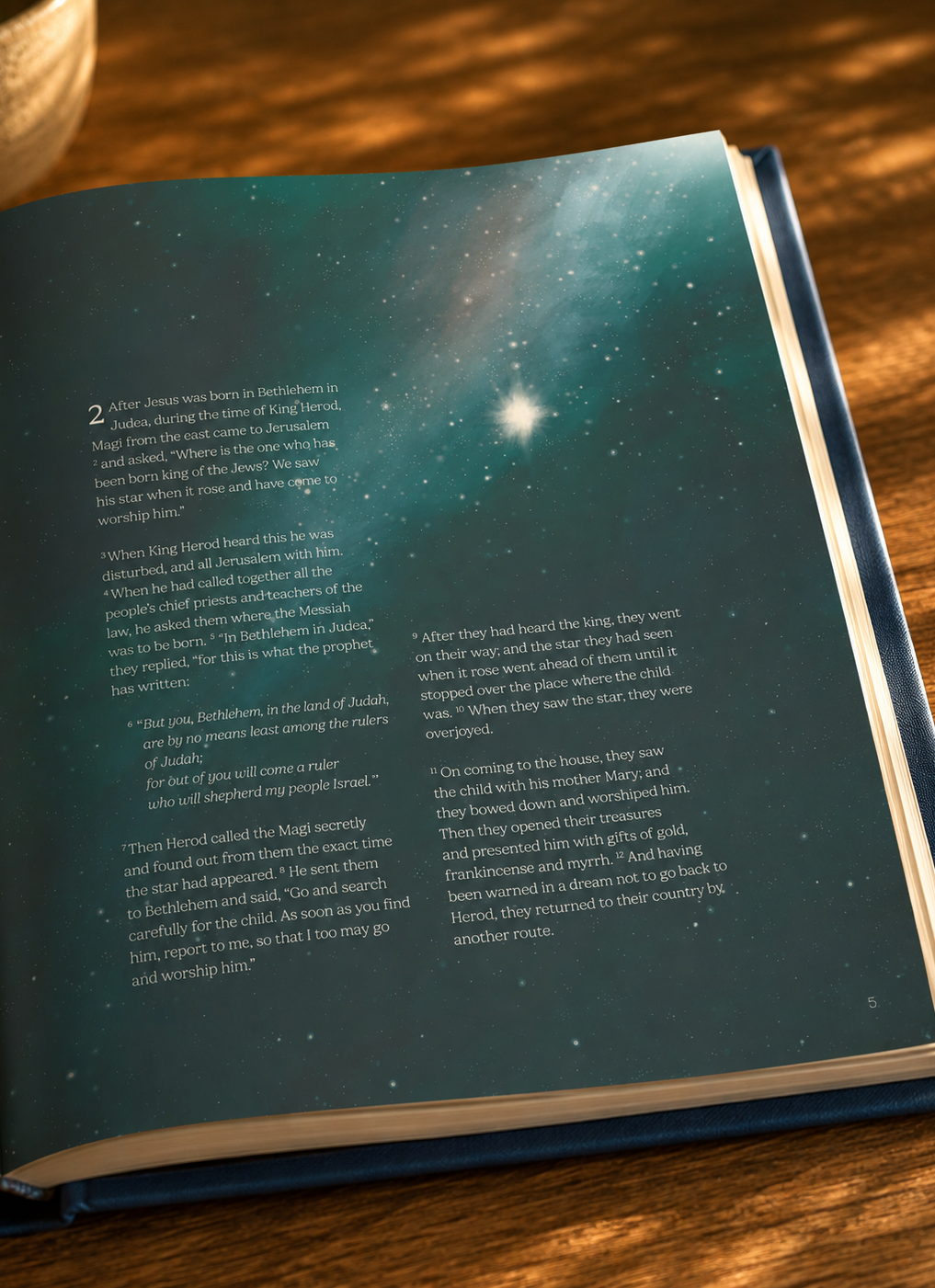 Open book with a space-themed illustration featuring a bright star and galaxy, on a wooden table.