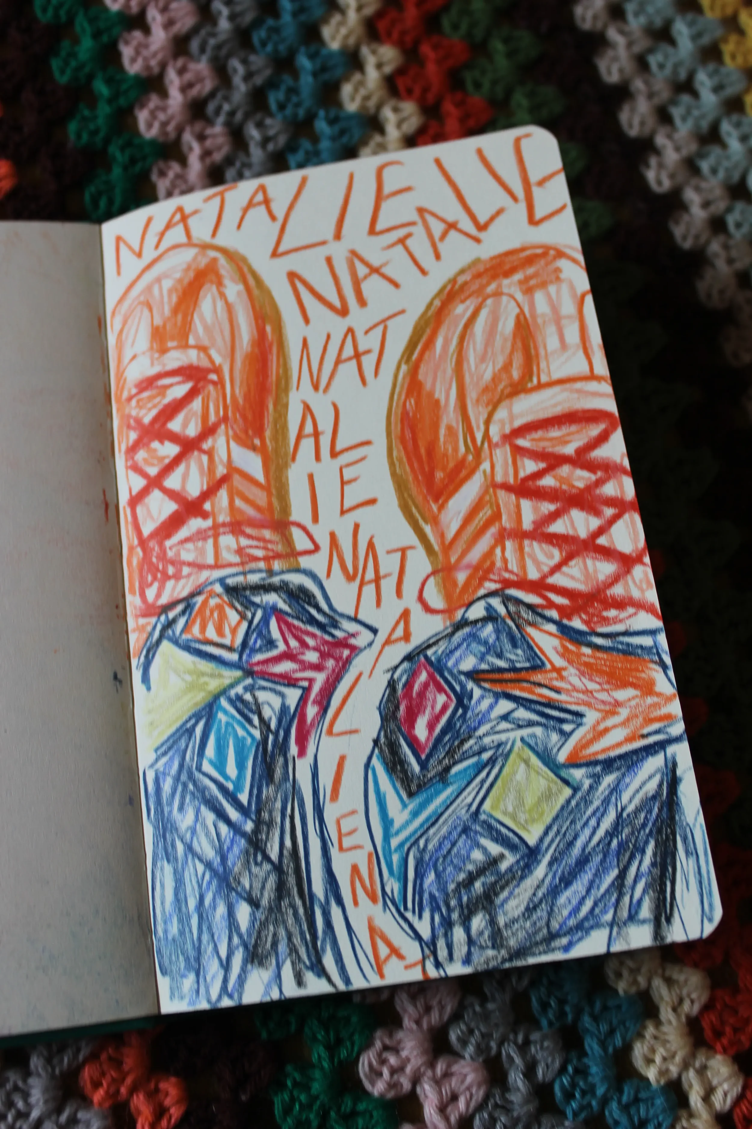 A colorful drawing of a pair of sneakers with the words "NATALIE" written above and around them, with rainbow-colored stars below. The drawing is on a white page with a multicolored, textured background.