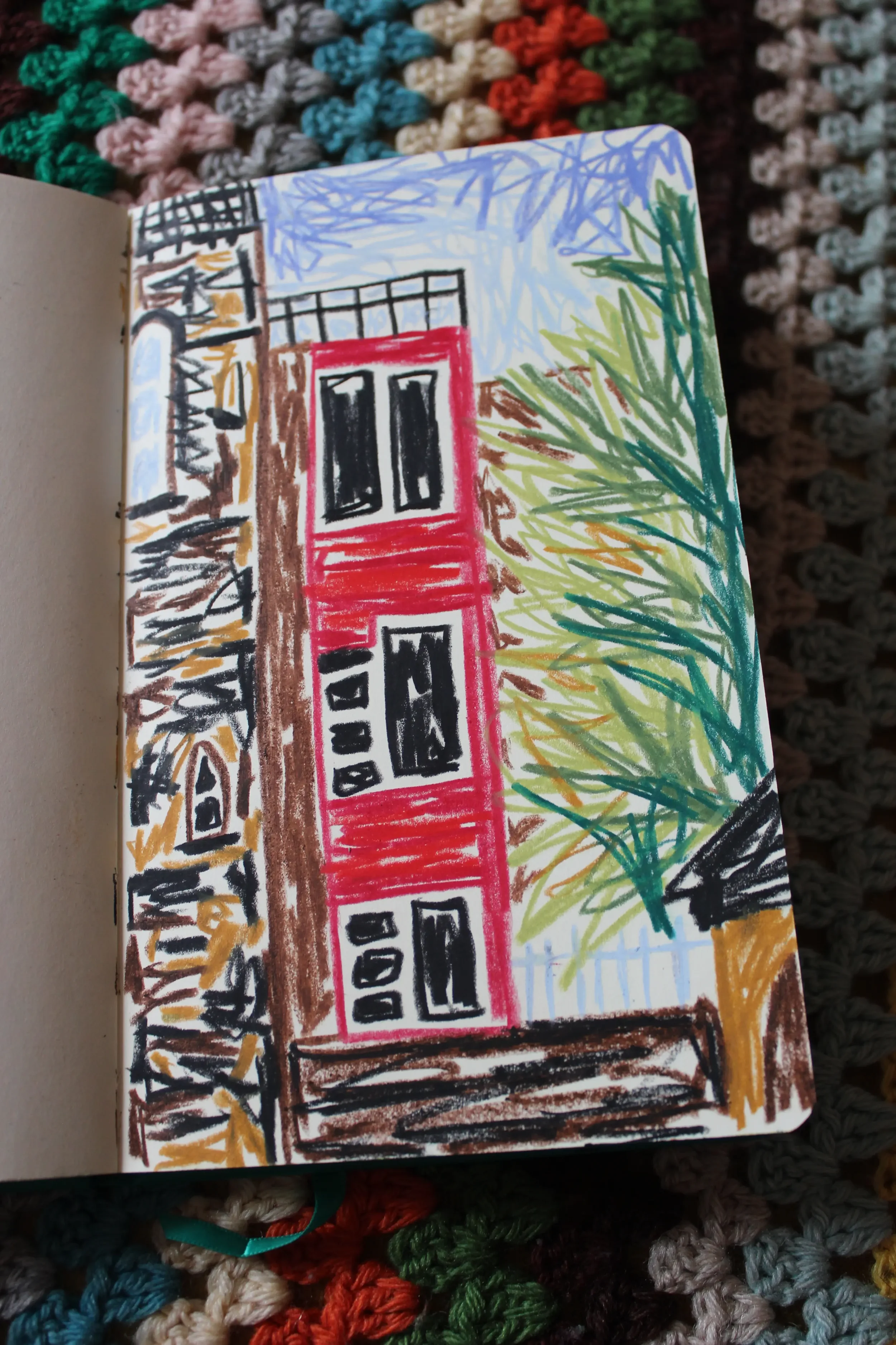 Colourful drawing of a house with black windows, a red door, surrounded by trees with green and brown foliage, and a blue sky in the background.