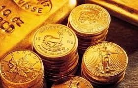 Stacks of gold coins on a dark surface.