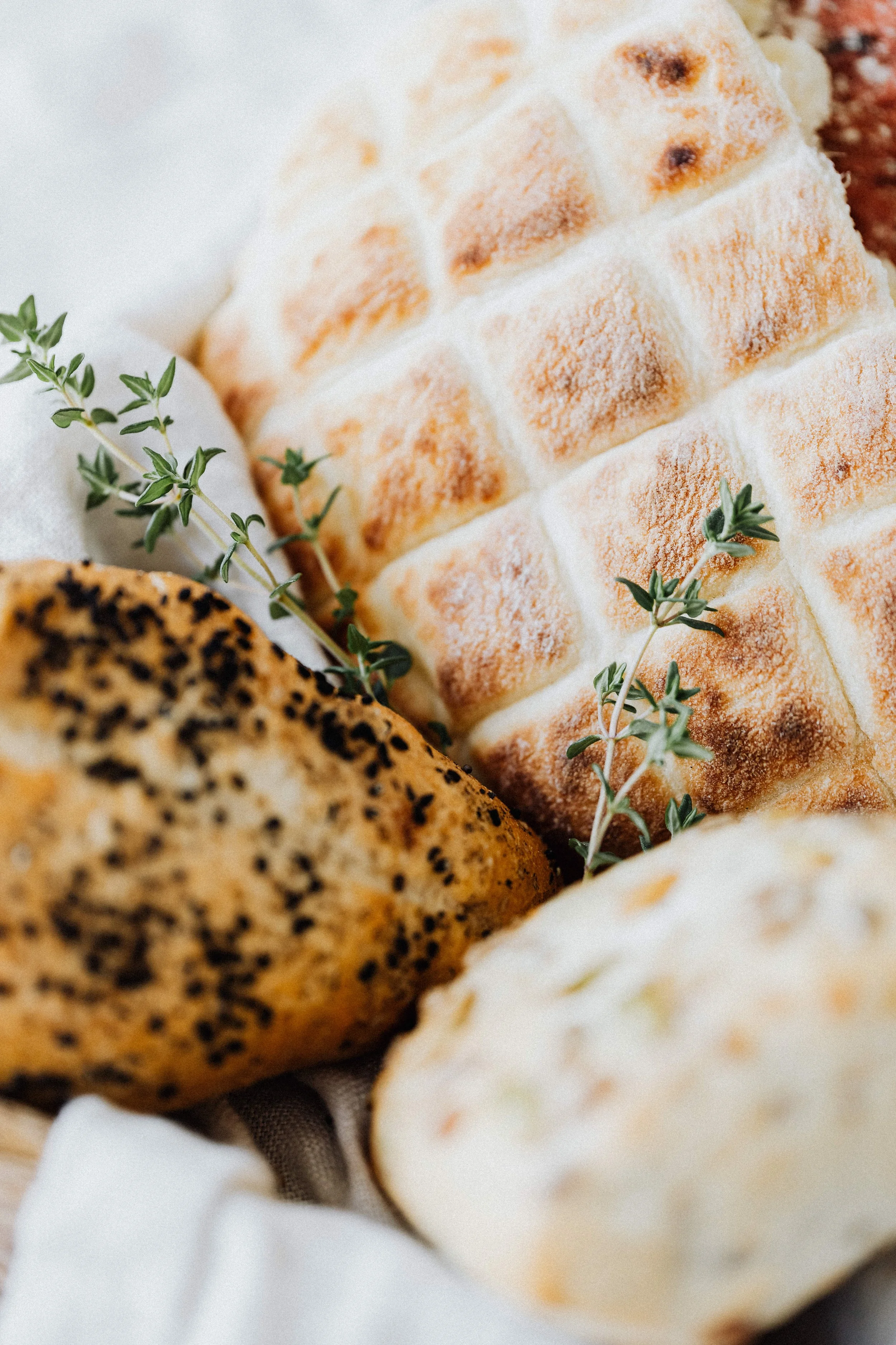 Close-up of assorted freshly baked bread with garnishing of herbs.