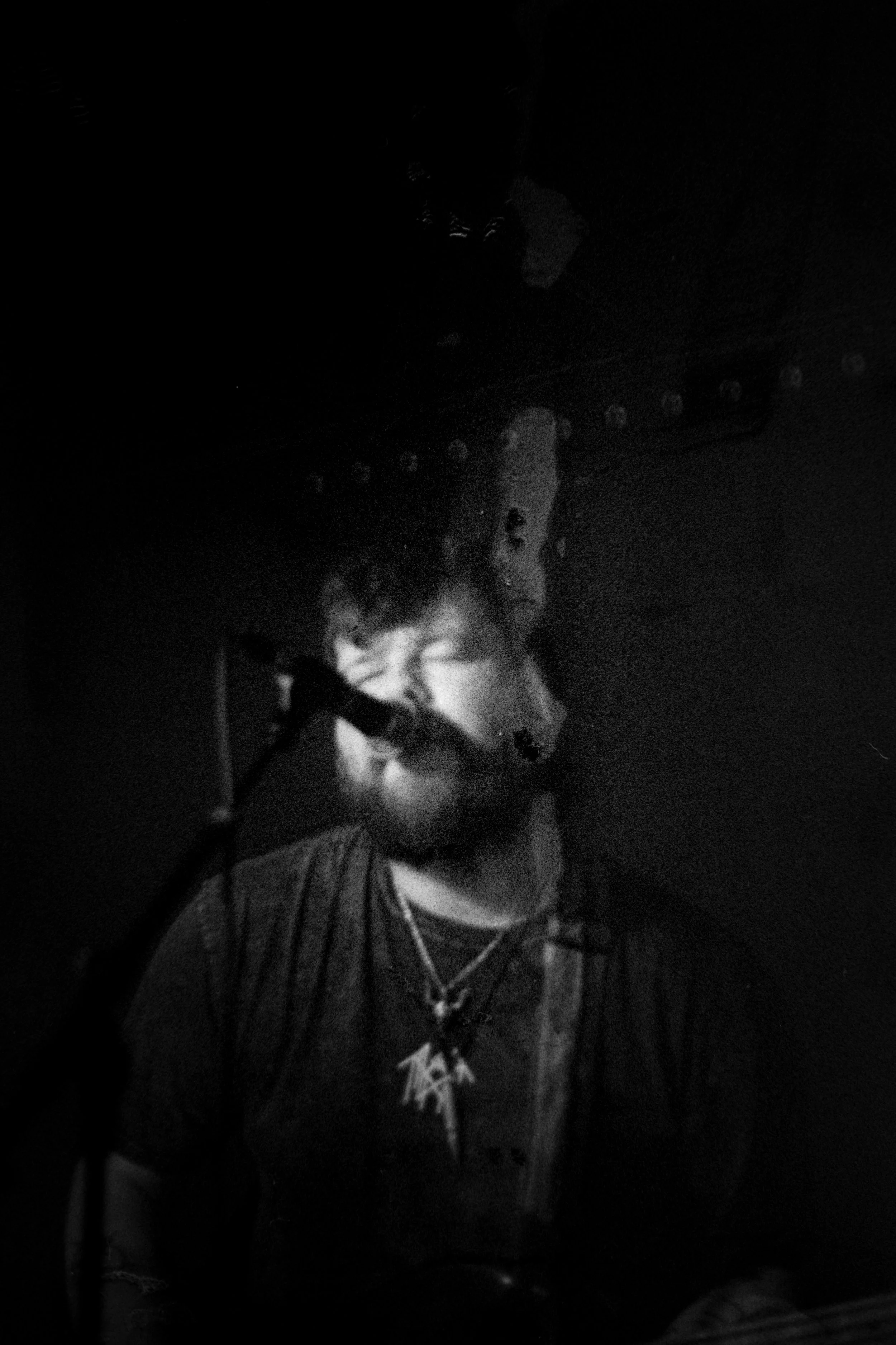 A person singing into a microphone in a dark room.