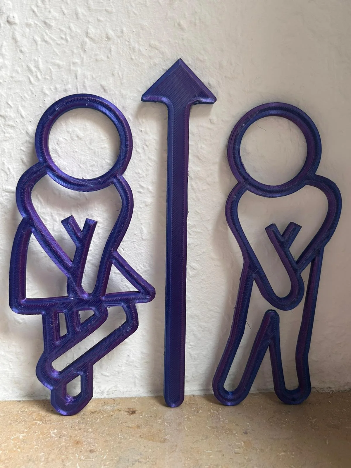 Zwei blaue Leuchtbuchstaben in Form von Frauen und Männern mit einem aufrechten Pfeil dazwischen, symbolisieren Gleichberechtigung.