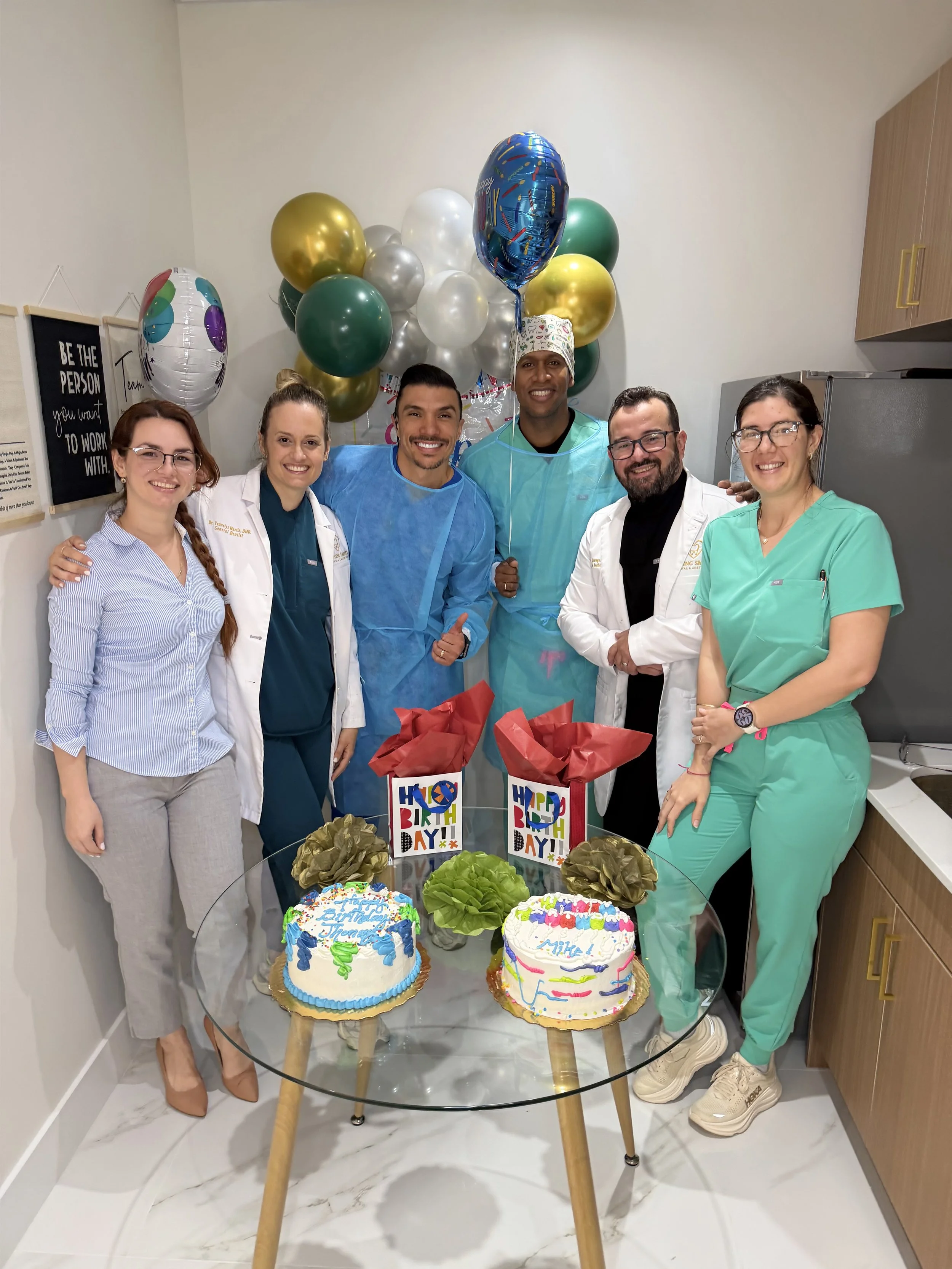 Dental team standing in the office lounge posing for a group picture