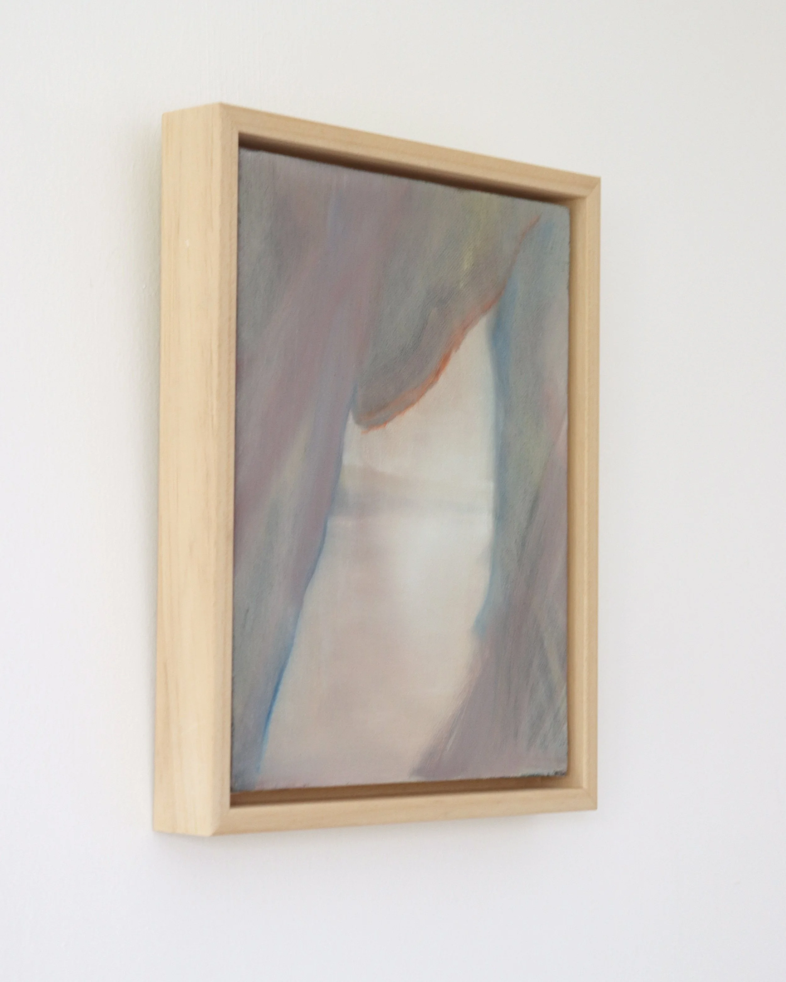 side view of painting in wooden frame, the painting shows a scene from inside caves looking out to the beach