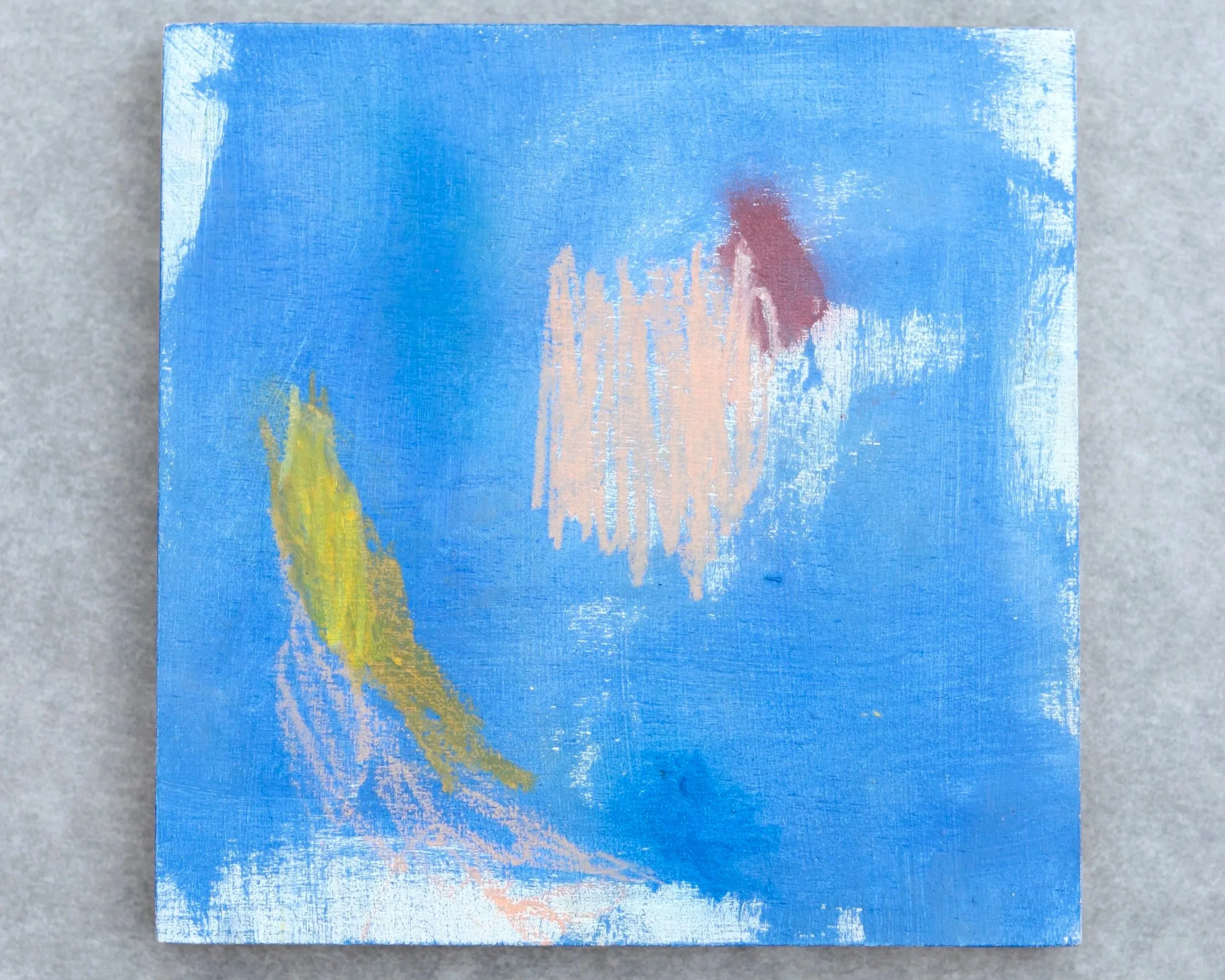 small blue abstract painting with yellow, pink and red shapes