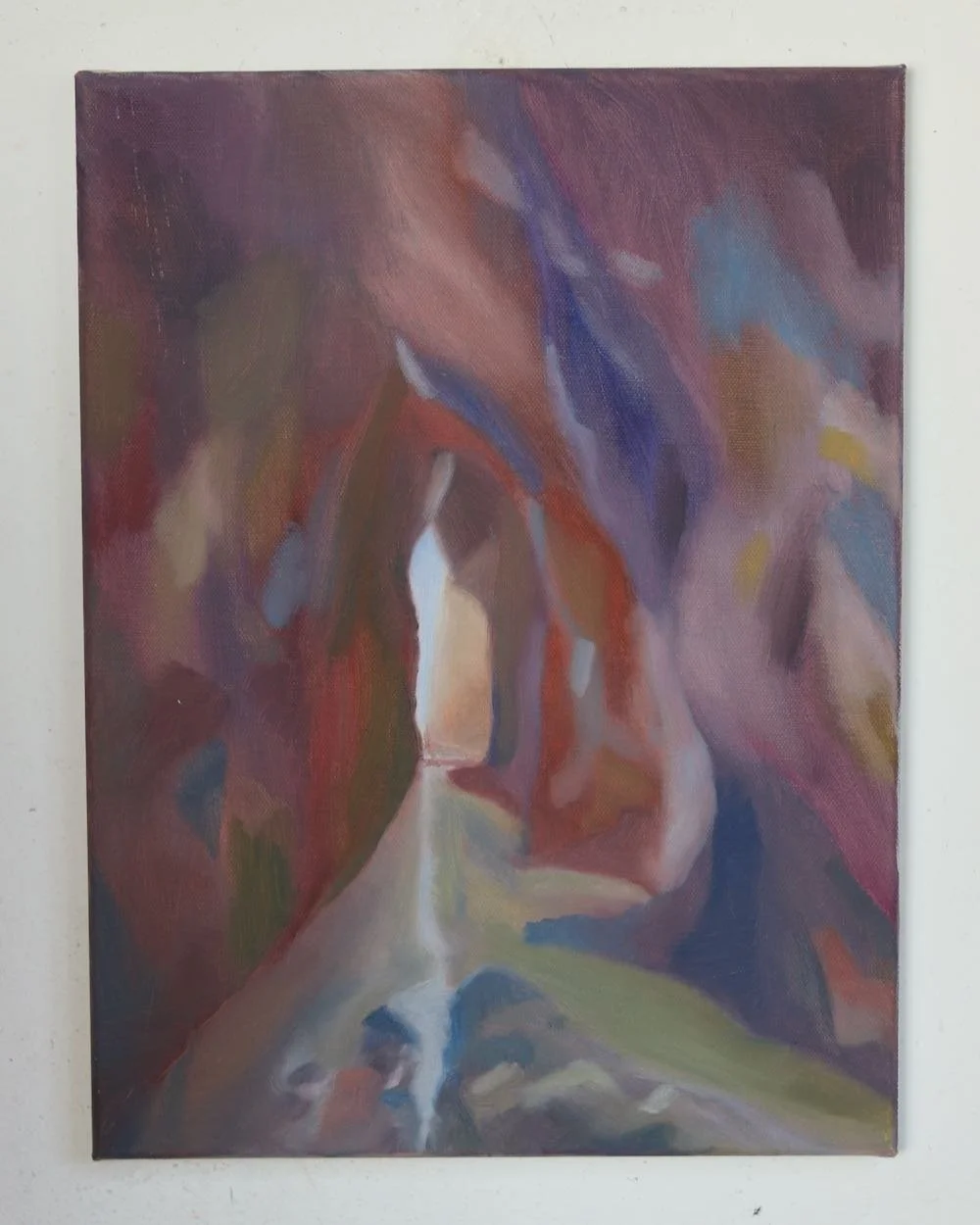an abstract painting showing a view from inside a cave, with deep purple, blue and red