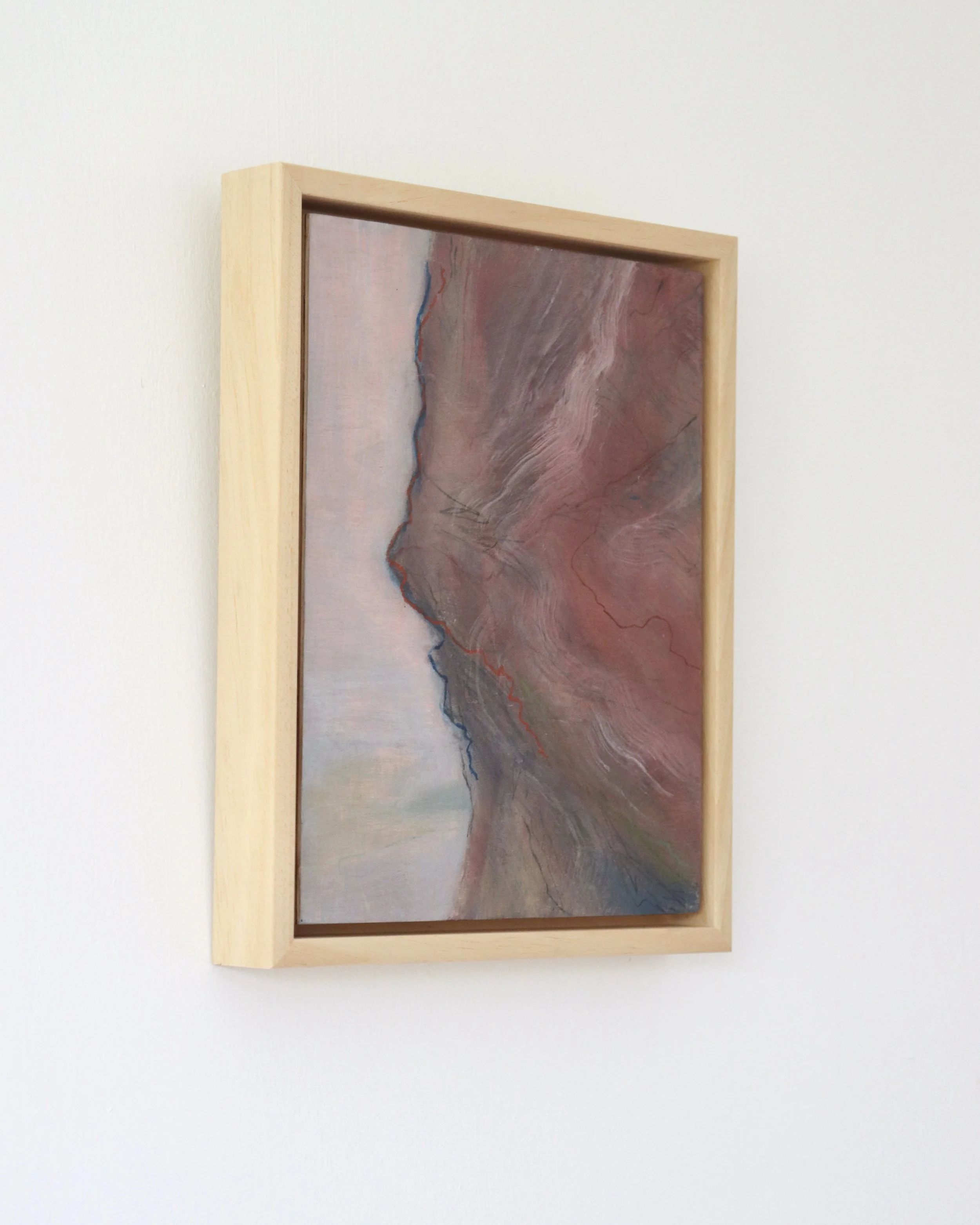 semi abstract painting featuring a weathered rock face show in a wood frame from a side angle