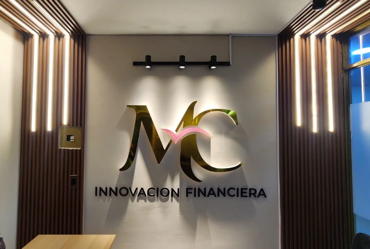 Logo de una empresa llamado 'Innovación Financiera' en una pared de oficina moderna con iluminación y decoración de madera.