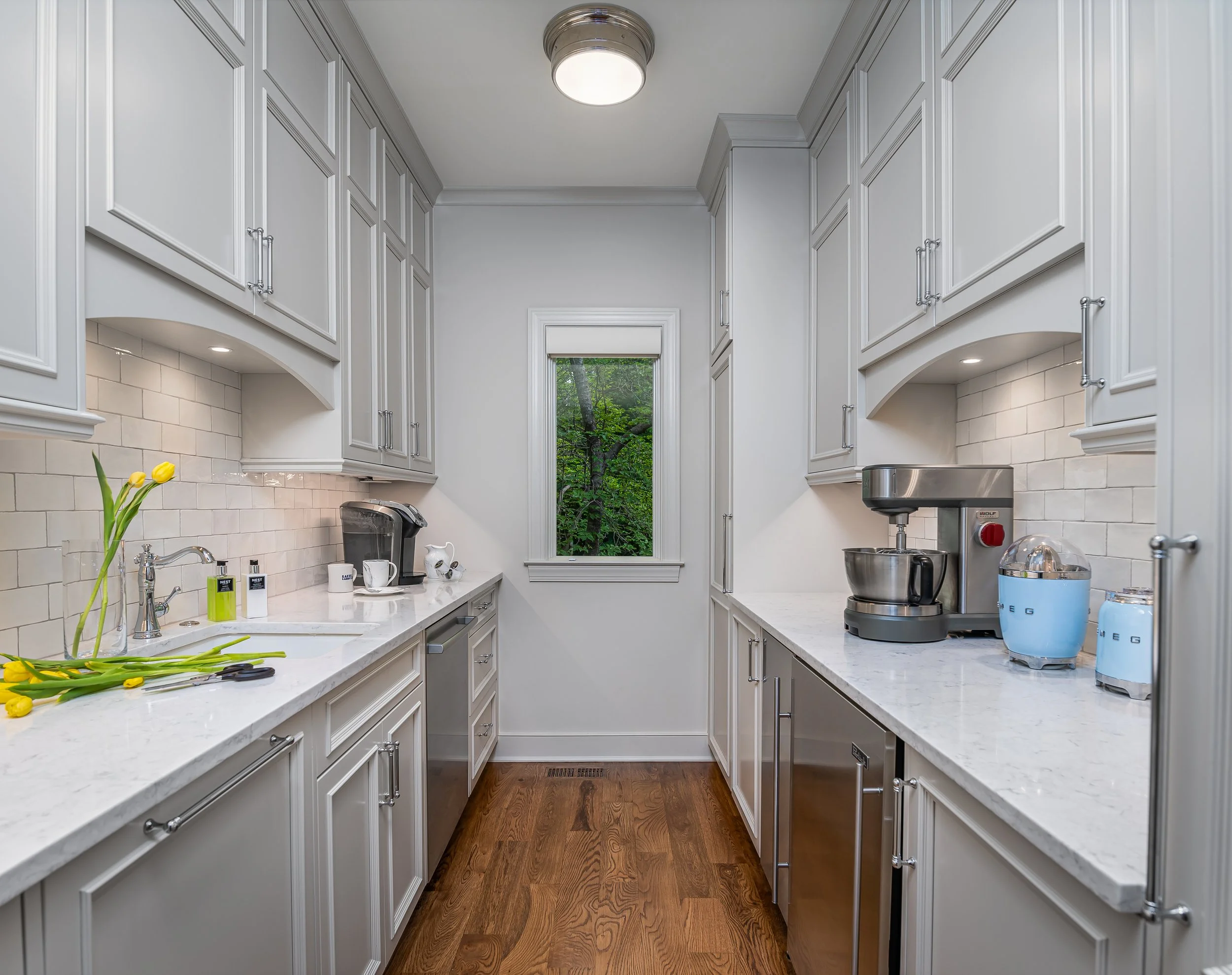Custom scullery with white cabinetry, stone countertops and integrated appliances in a Buckhead Atlanta home near Paces Ferry.