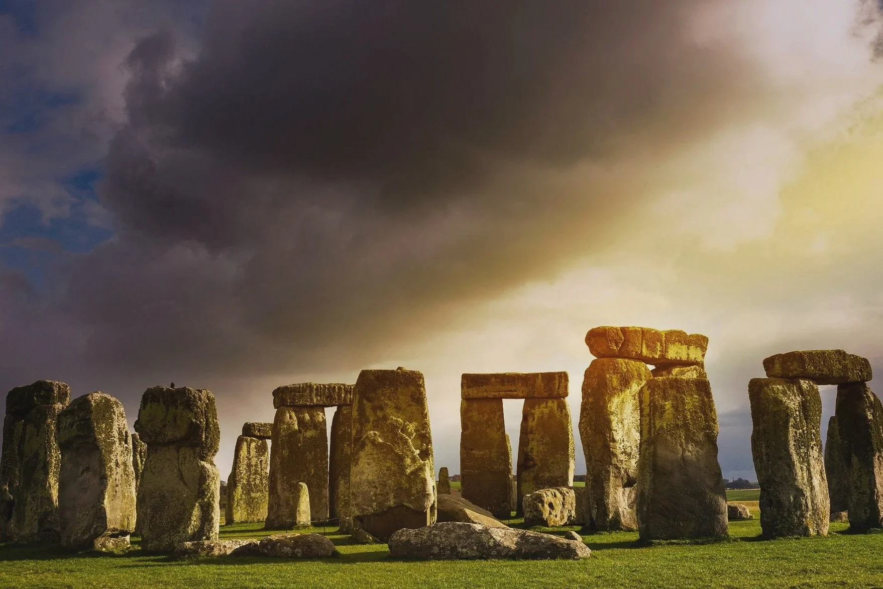 Historic Stonehenge monument with large standing stones and a cloudy sky at sunset.