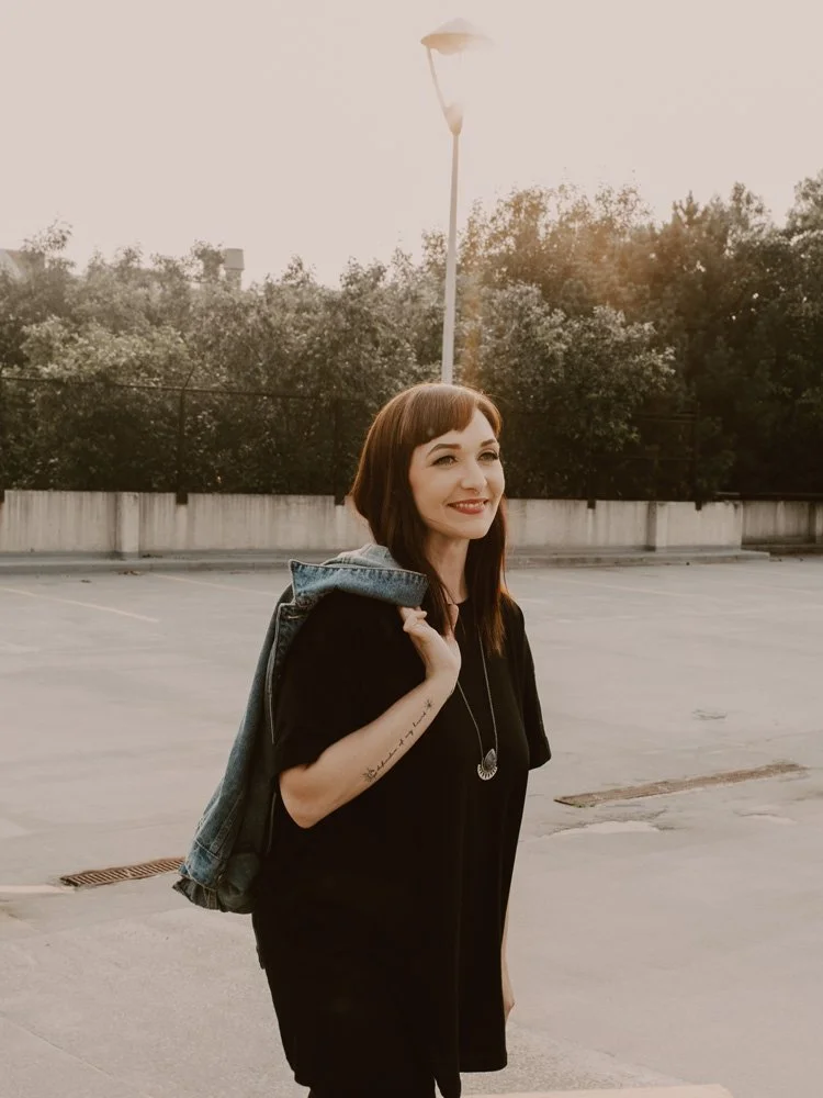 Abigail Paulson walking through a sunny lot and smiling.