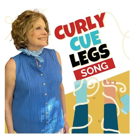 Lady in blue smiling next legs with curly things