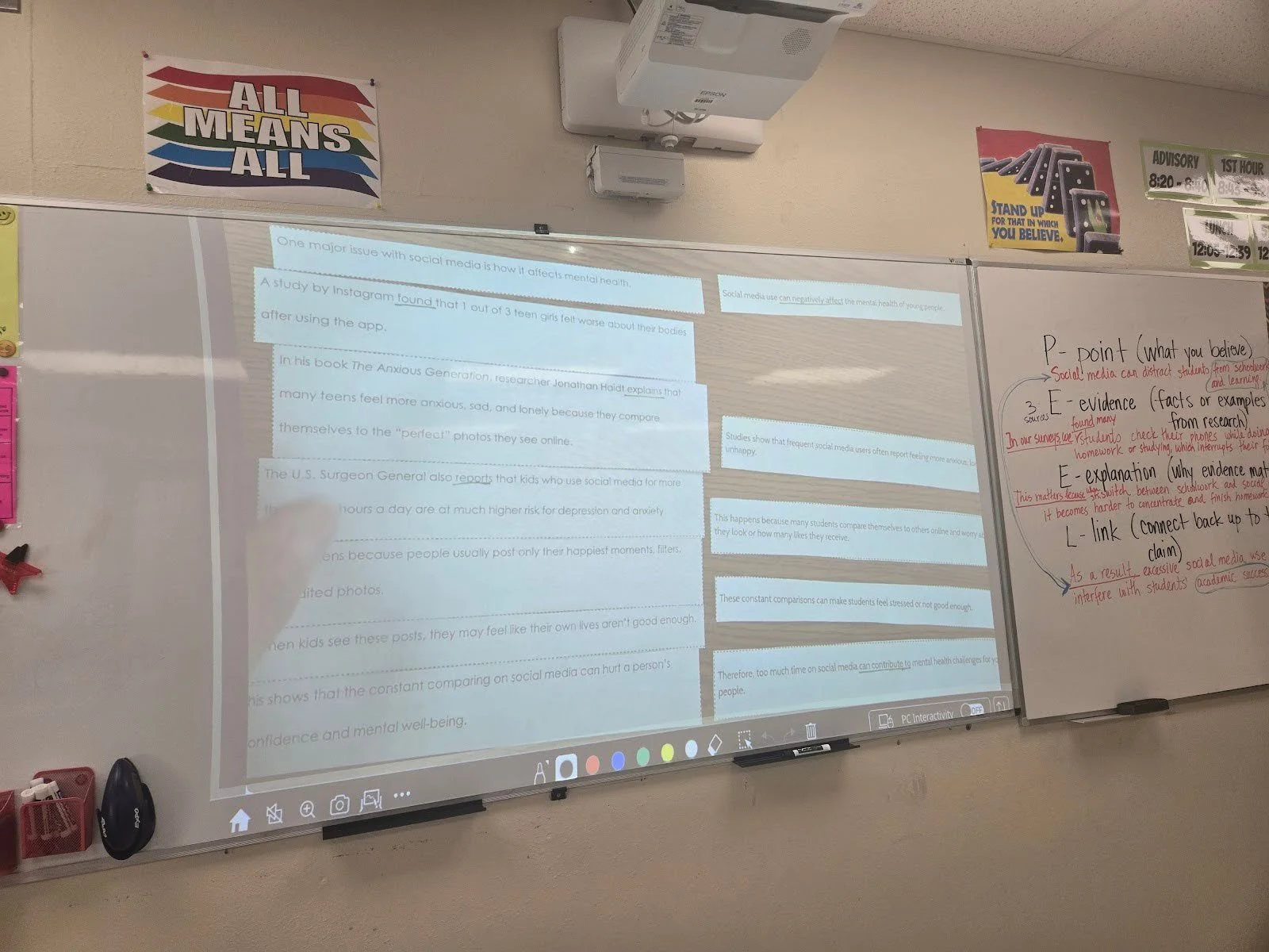 Teacher pointing to definition sentences on a projector