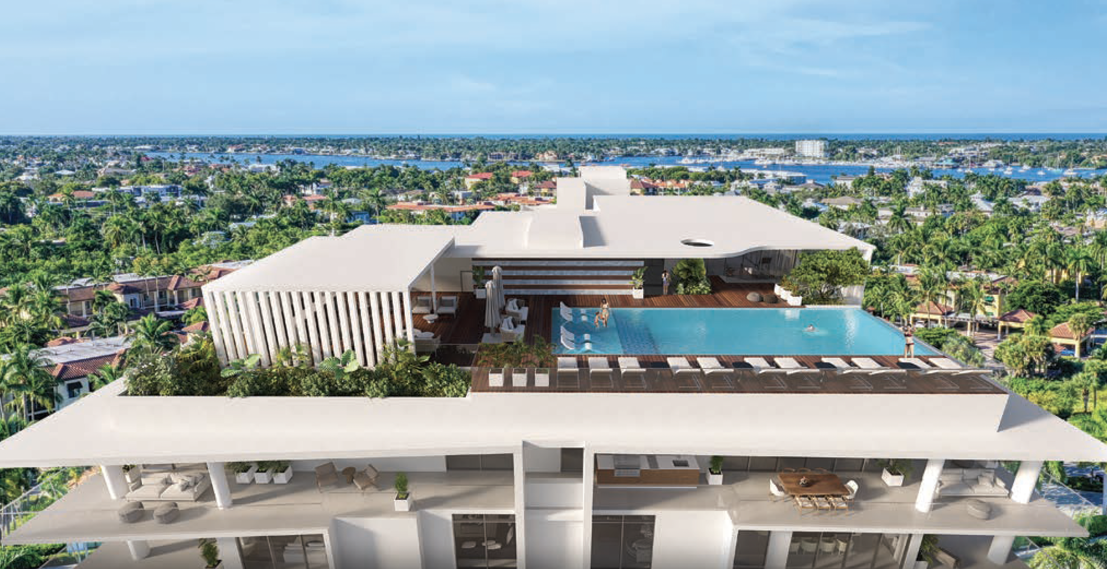 A modern rooftop pool area with lounge chairs, umbrellas, and greenery, overlooking a cityscape with water and trees in the background.