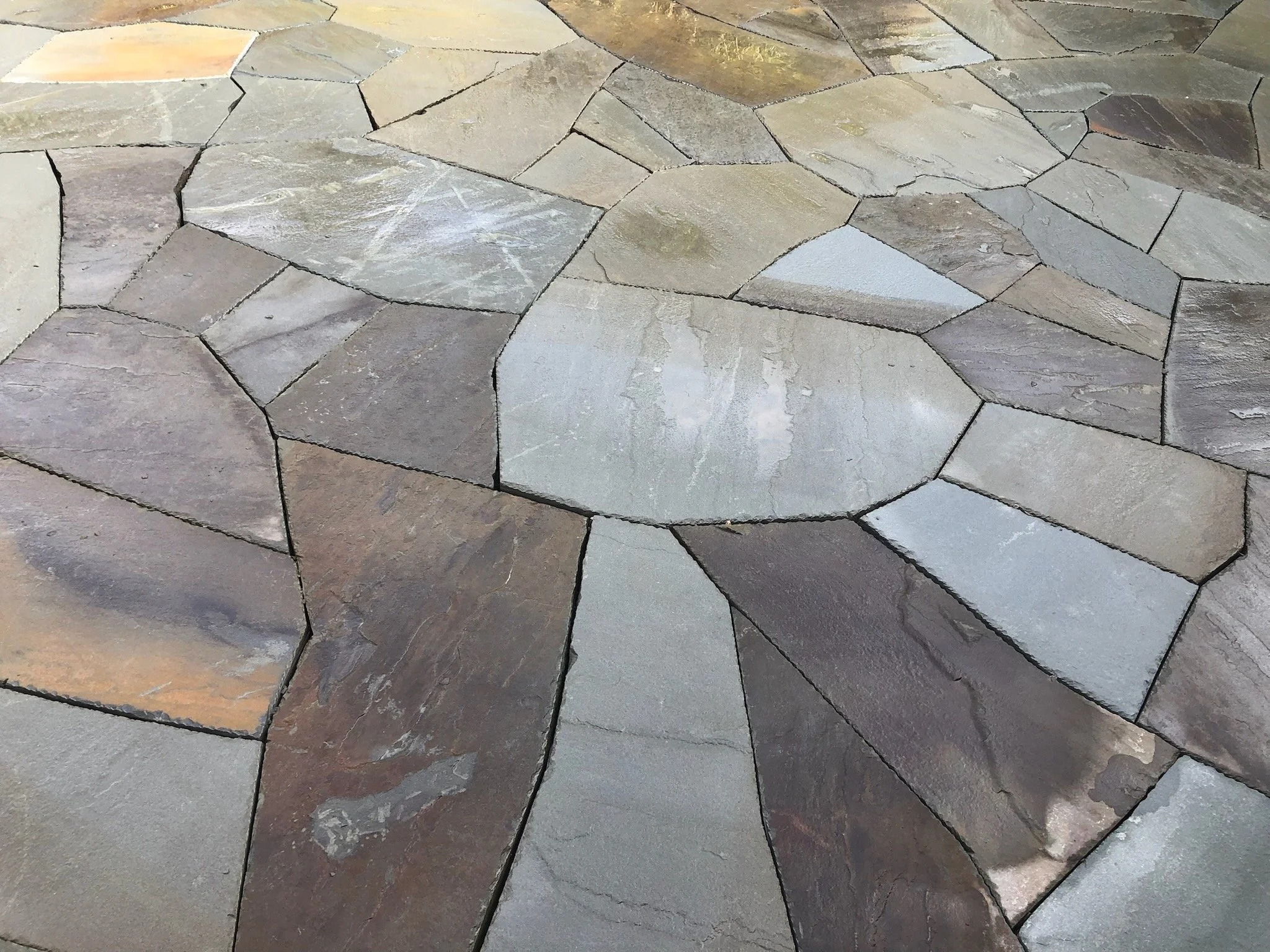 Close-up view of a stone pathway with irregularly shaped, multicolored flagstones.