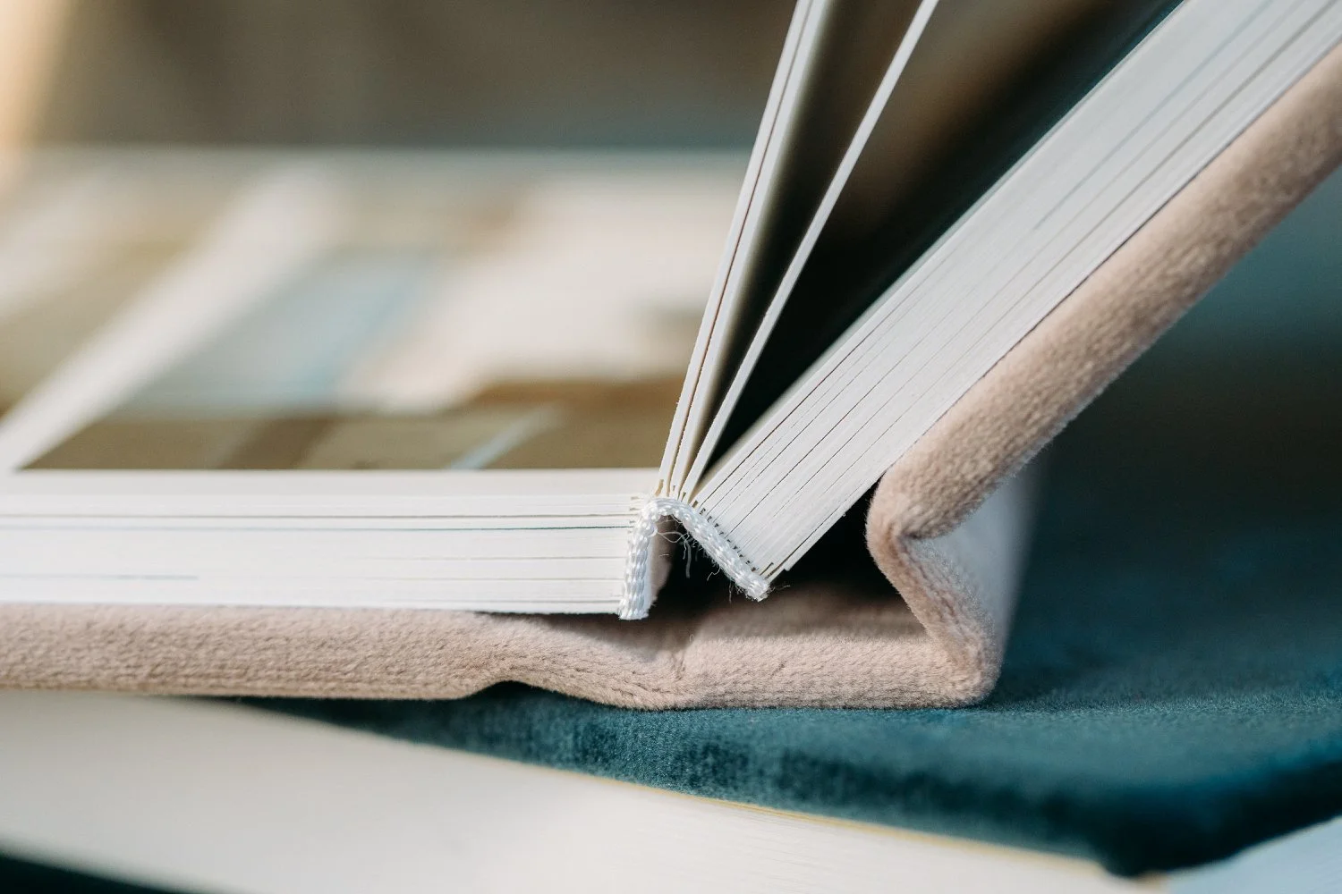 Nahaufnahme eines offenen Buchs mit dicken Seiten, das auf einem Stoffuntergrund liegt.