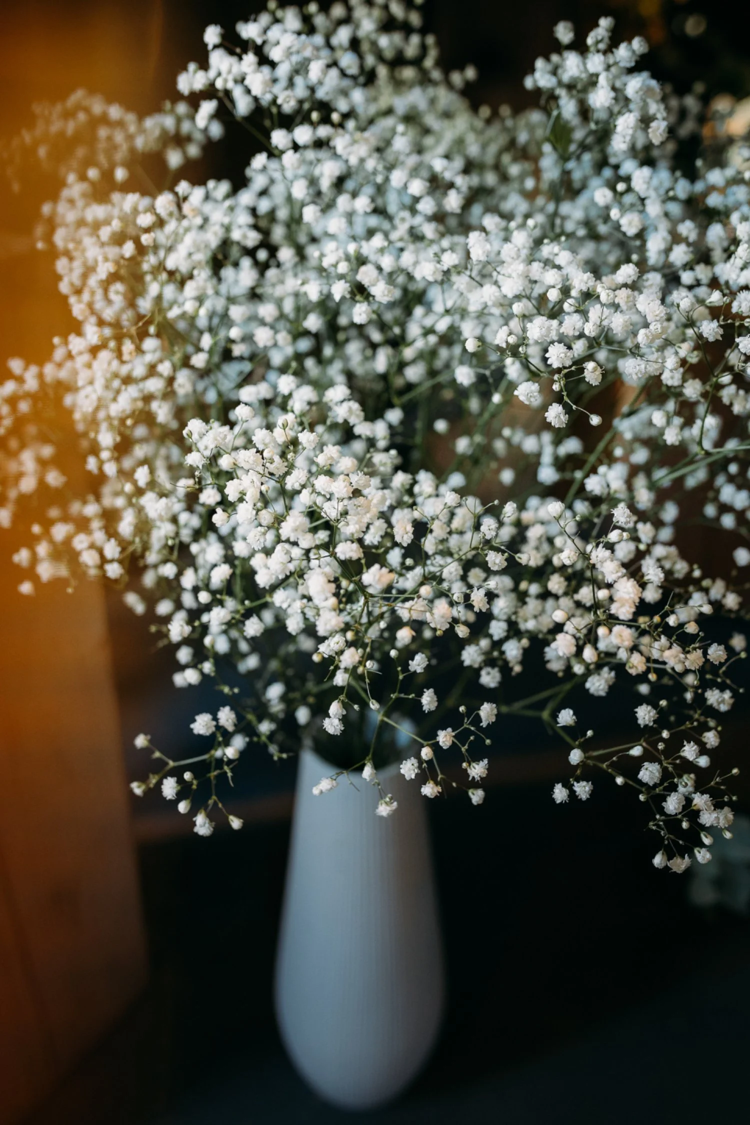 Weisse Blumen in einer Vase auf einem Tisch.