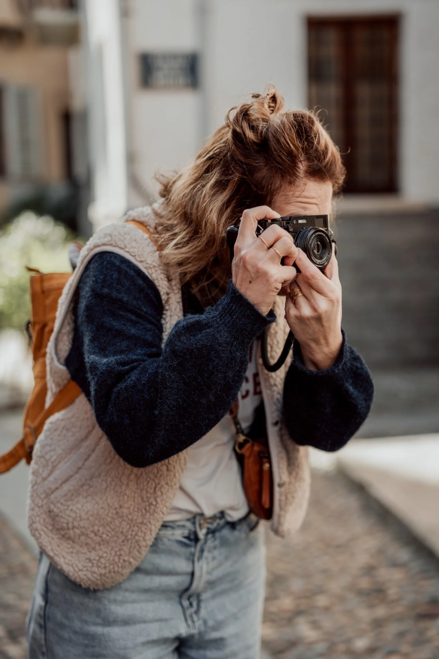 Frau macht ein Foto mit einer Kamera auf einer Strasse im Freien