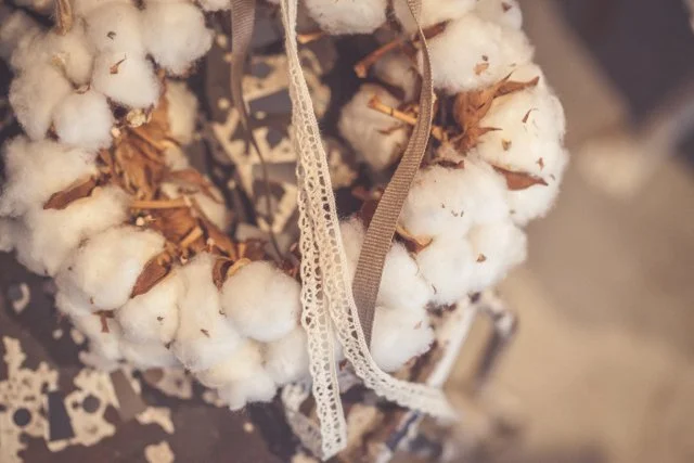 Ein Kranz aus Baumwolle mit weissen Schleifen und Spitze.