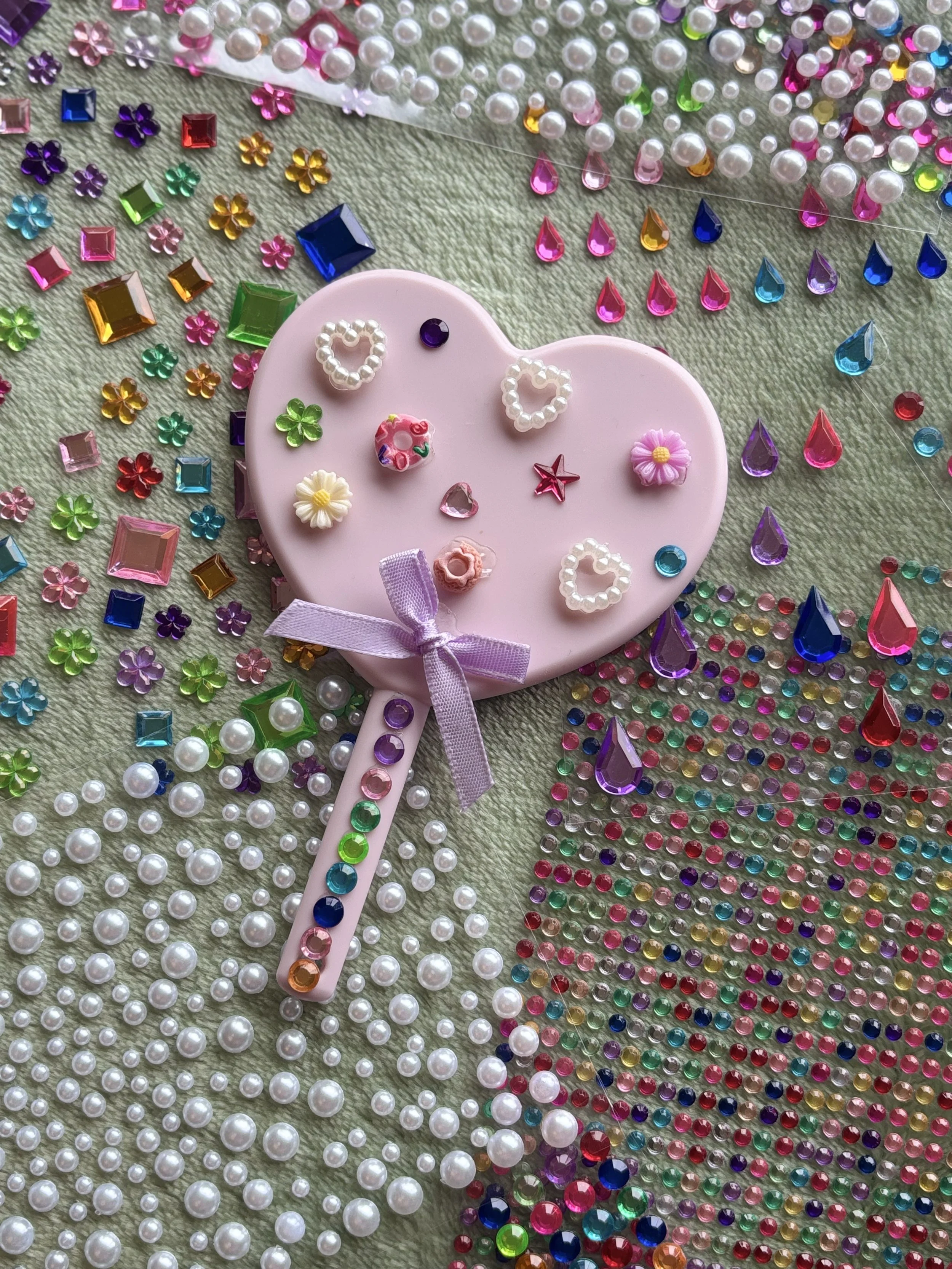decorated hand held mirror surrounded by rhinestones and pearls