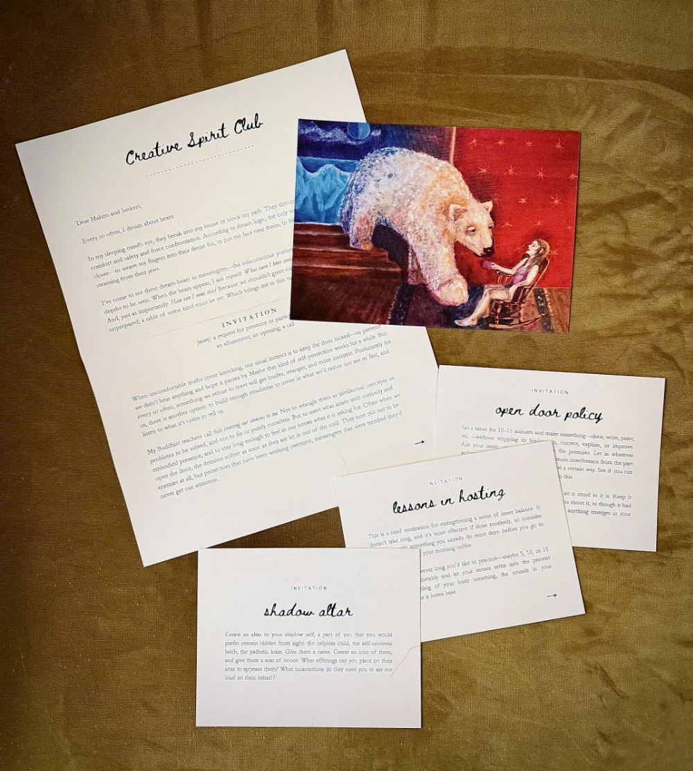 A set of printed documents on a wooden surface, one titled 'Creative Spirit Club,' with various handwritten invitations and a colorful postcard featuring a white bear and a girl sitting in a red chair.