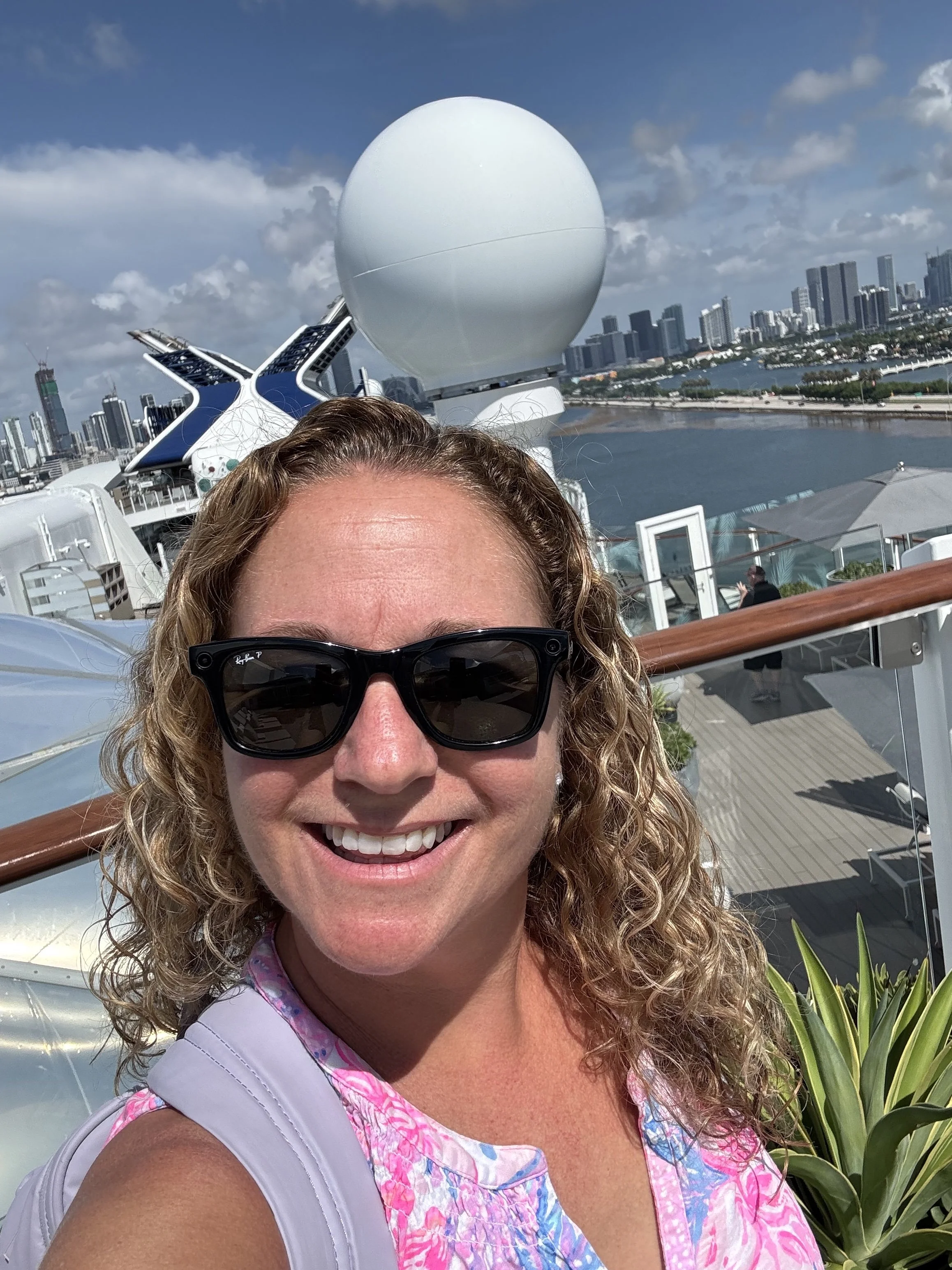 Travel advisor Danielle on the top deck of Celebrity Beyond during a ship tour in PortMiami, with the Miami skyline behind her.