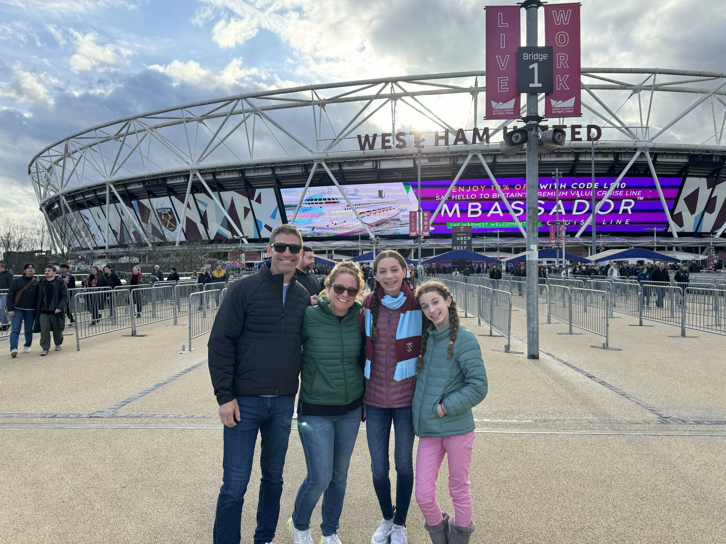 Family in West Ham United scarves outside London Stadium for Premier League match