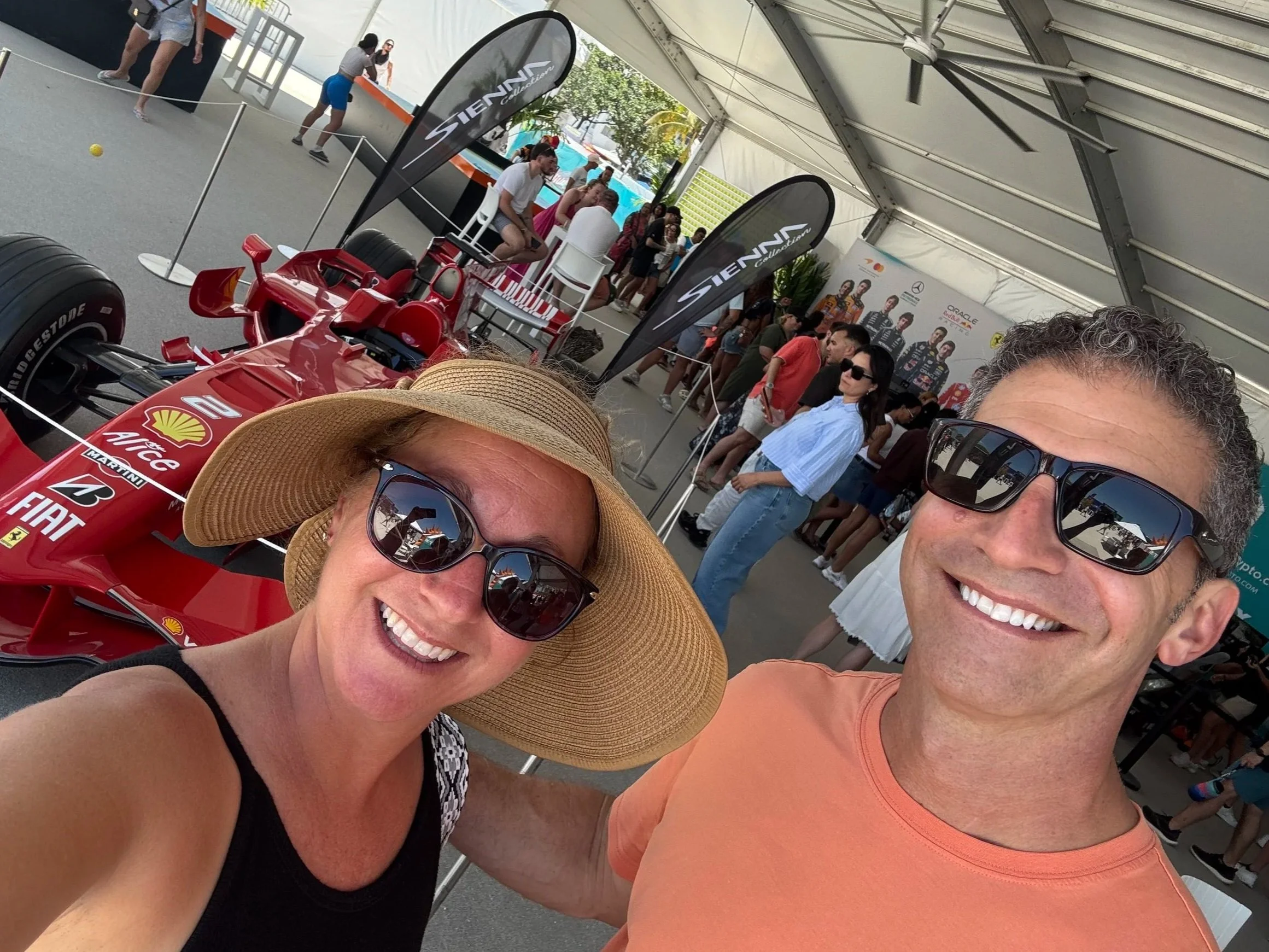 Couple at Miami Grand Prix paddock with F1 race car