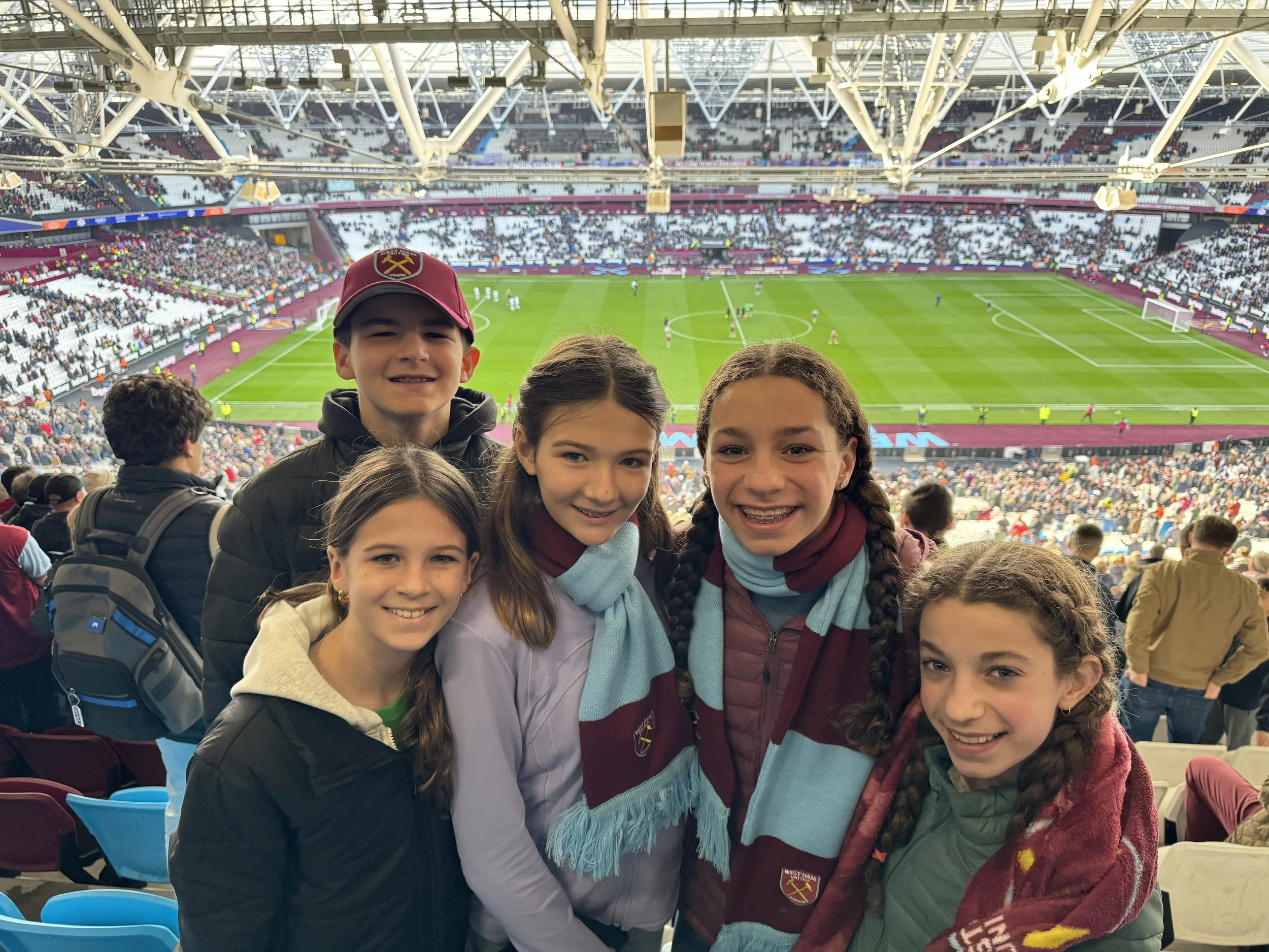 Family in West Ham scarves in stadium seats before kickoff
