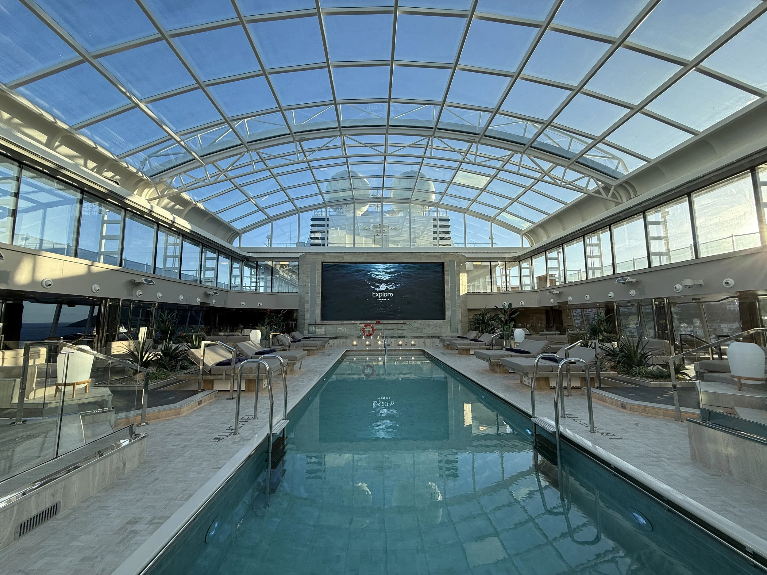 Explora Journeys indoor pool beneath a retractable glass roof, part of the Ocean Wellness experience