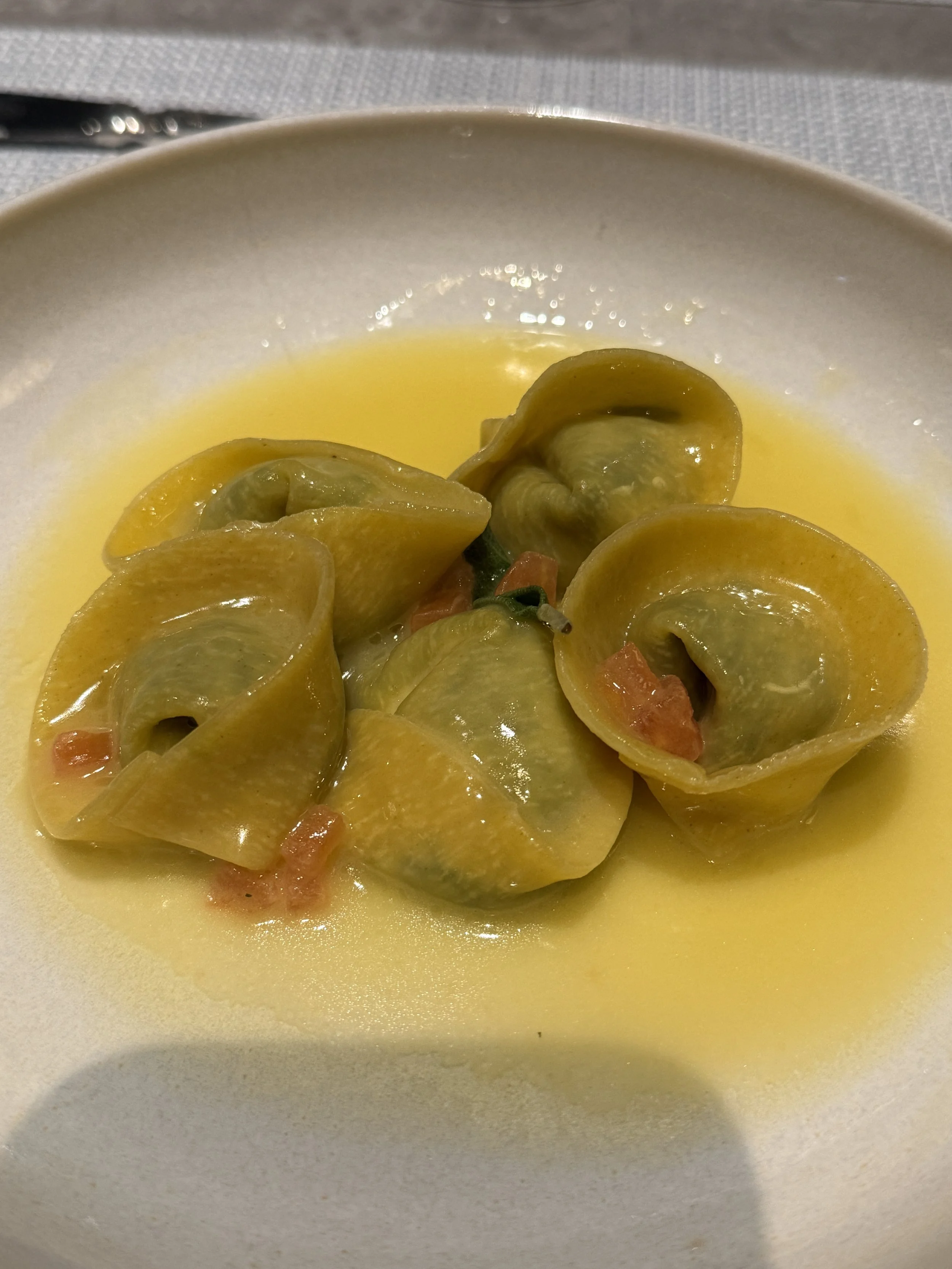 Delicate stuffed pasta in a light broth, plated at an Explora Journeys dining venue