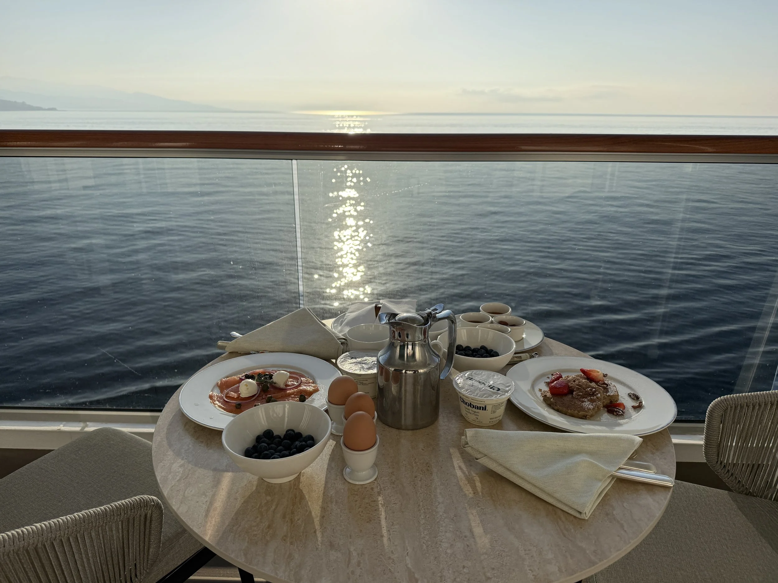 In-suite breakfast on a private balcony overlooking a calm sea aboard Explora Journeys