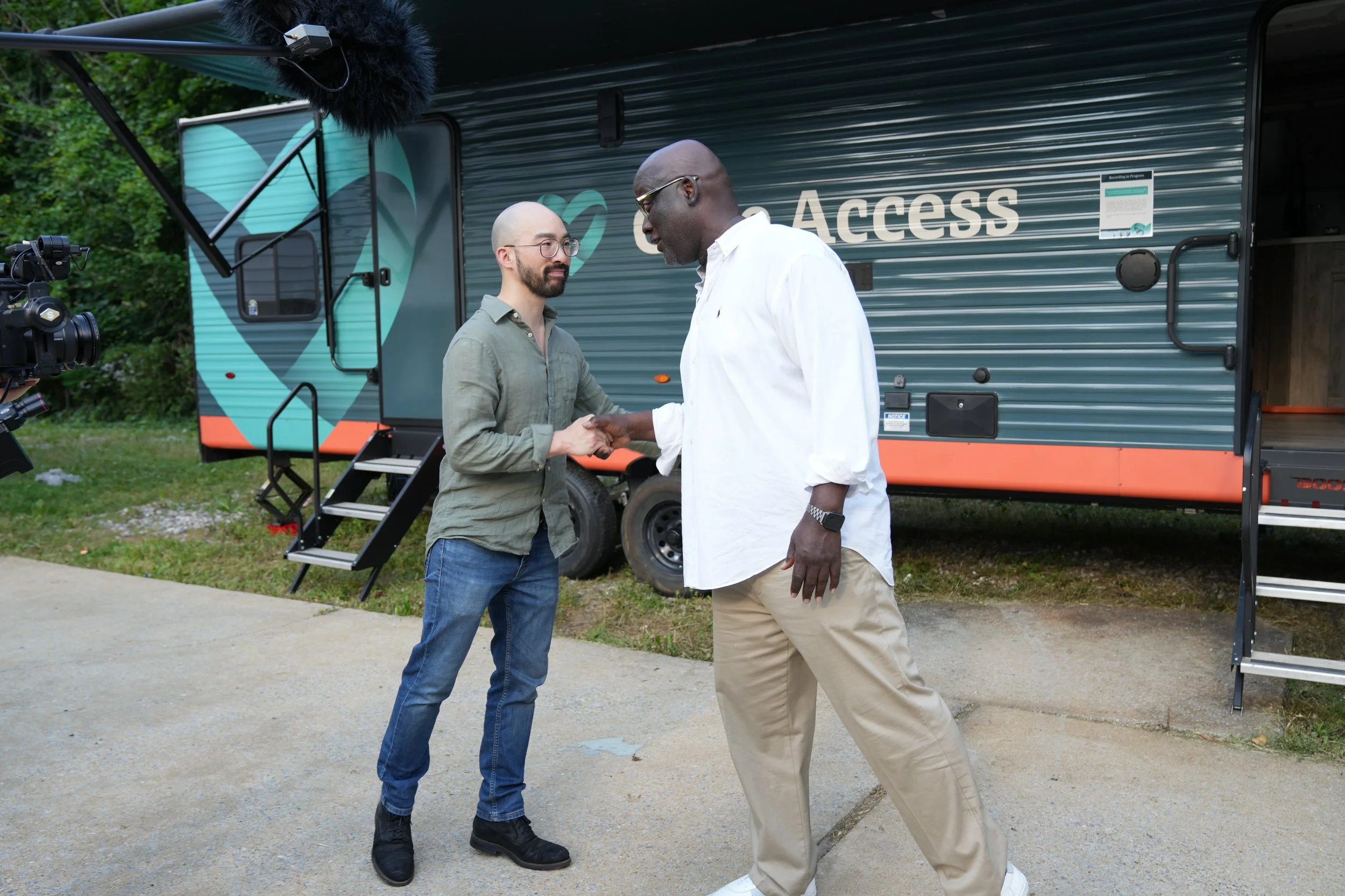 Michael Lin, Co-Founder of Care Access, shakes hands with Dr. Terris King of King Enterprises LLC, marking their collaboration at the West Baltimore Difference Makers House.