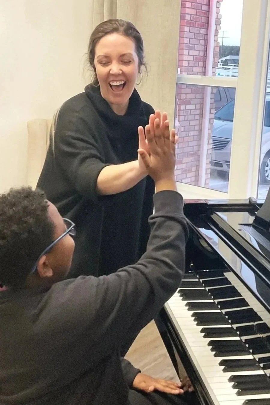 Piano teacher and student enjoying a beginner piano lesson in Falcon, Colorado.