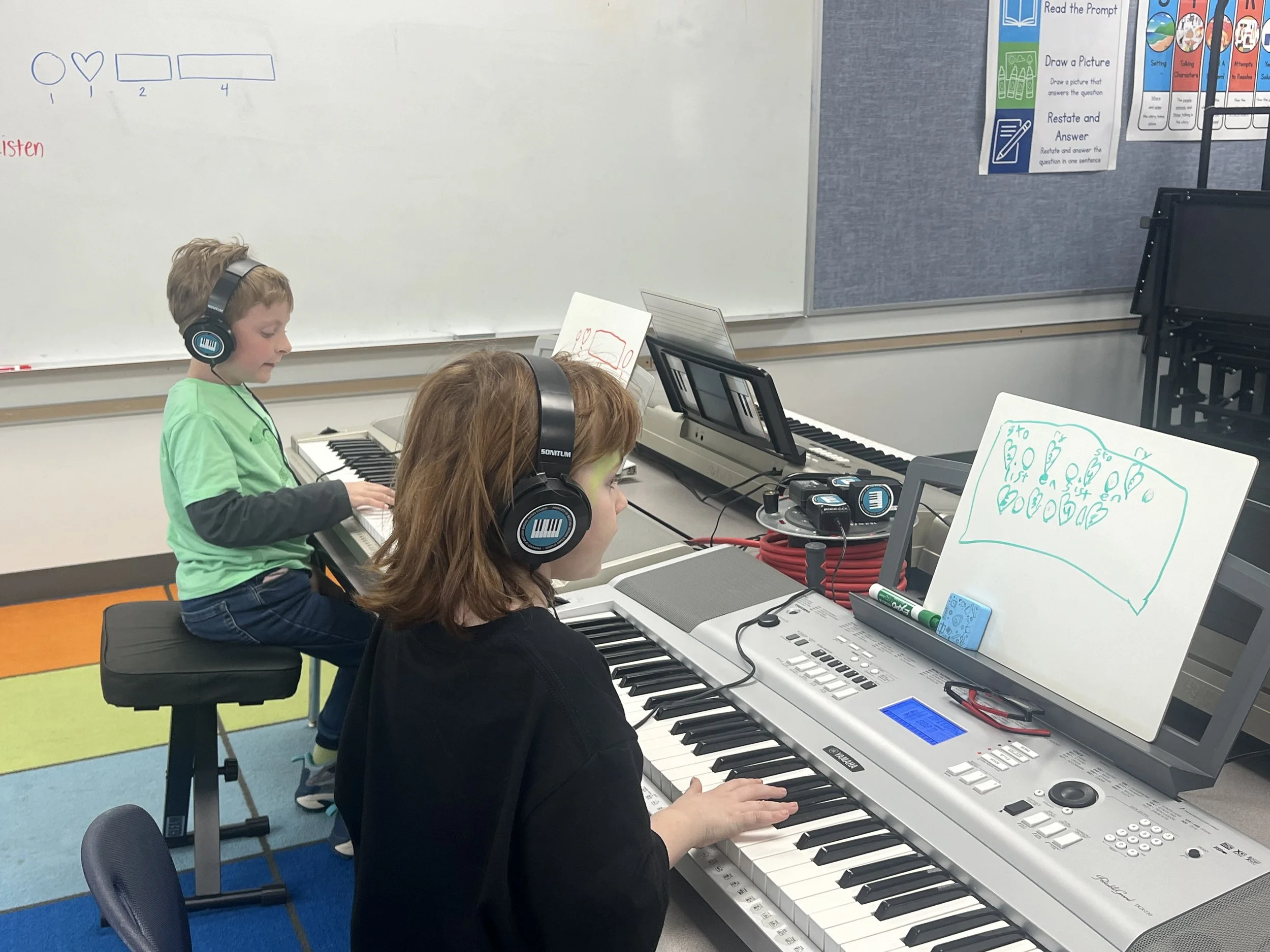 Children learning piano skills on digital keyboards in a group piano class.